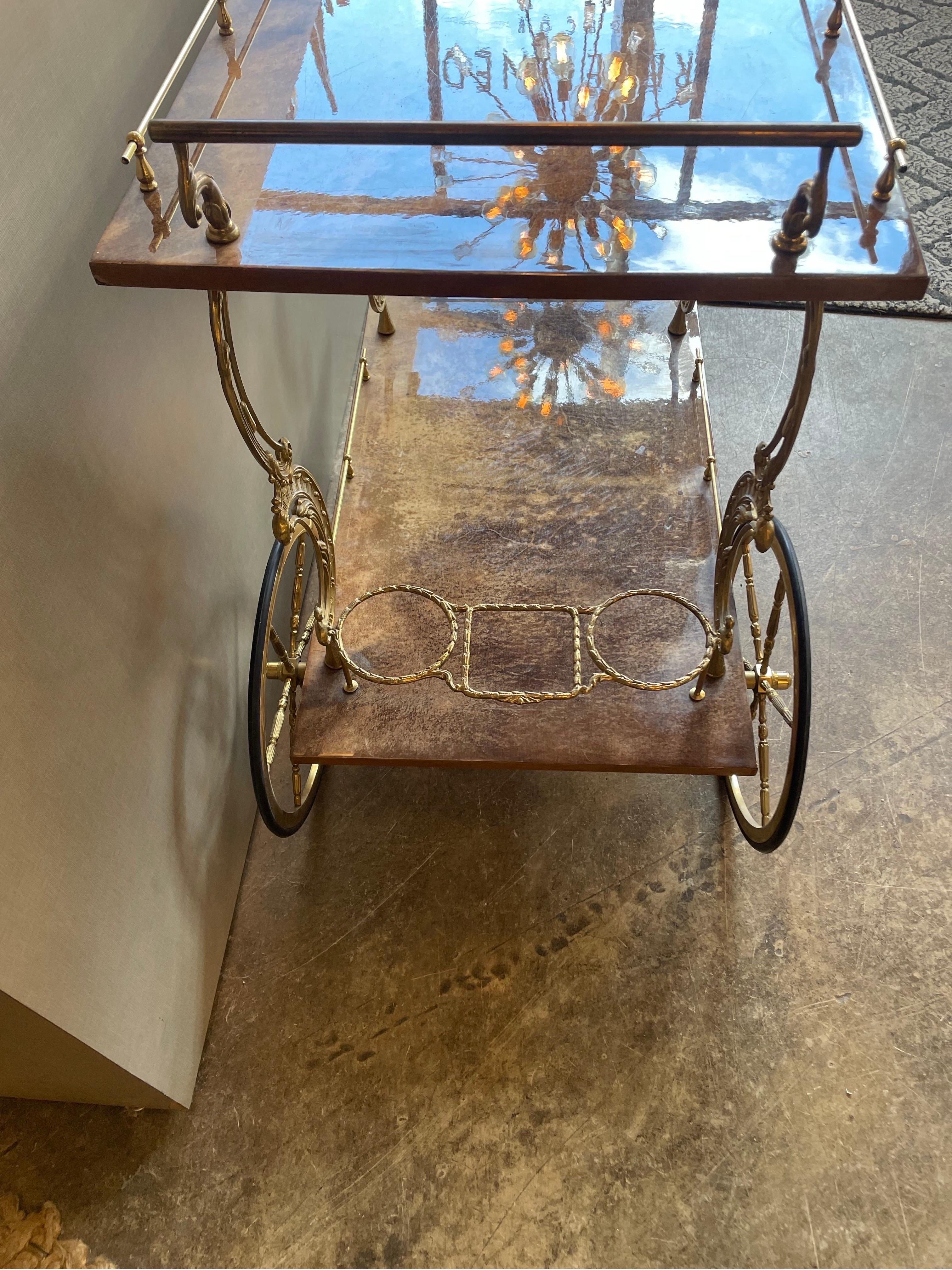 This is an Italian lacquered goat skin and brass bar cart in the manner of Aldo tura  
The color is a rich brown 