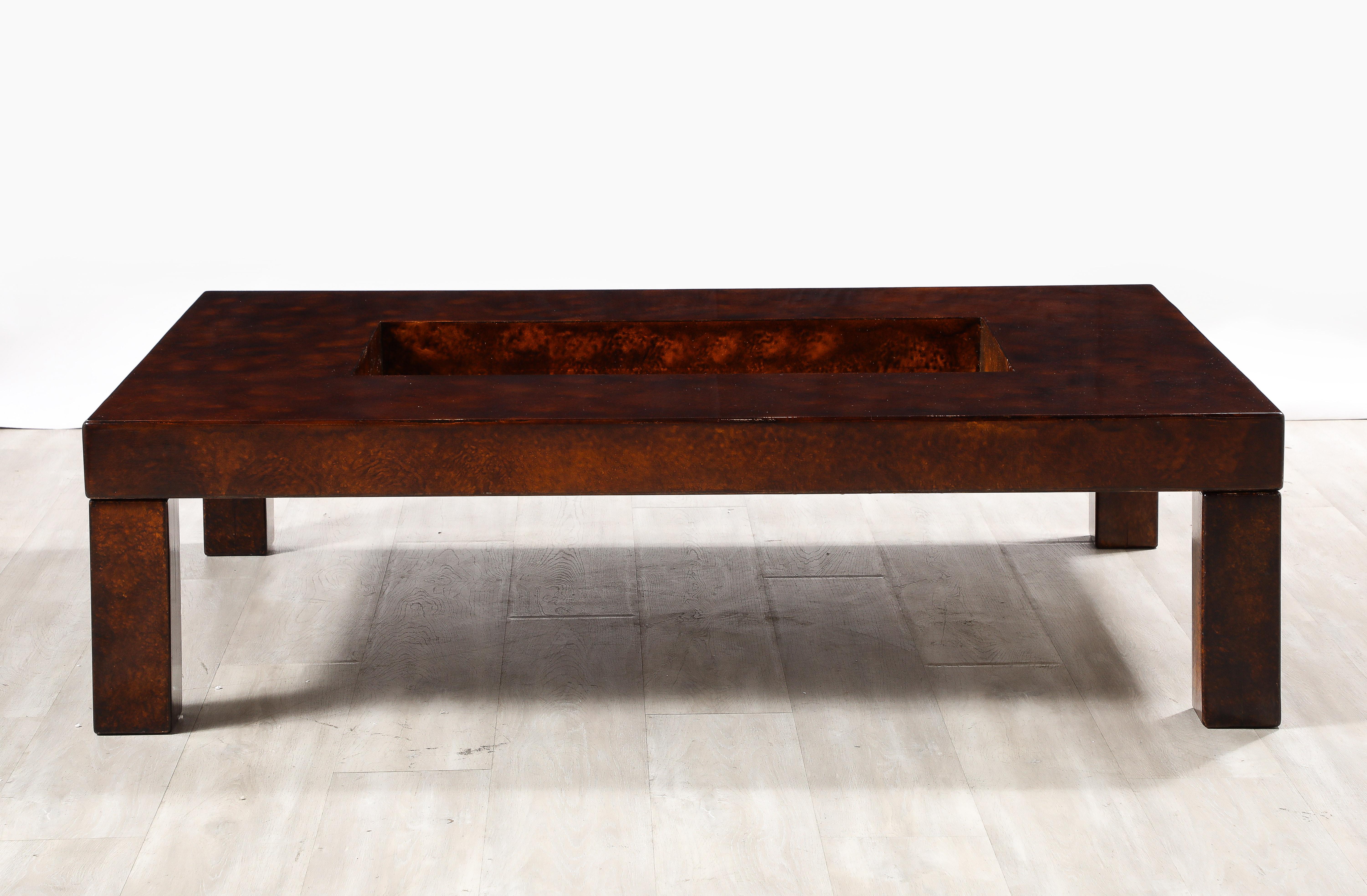 A beautiful lacquered goatskin coffee table with brass center, by Aldo Tura, Italy circa 1975. This high gloss lacquered goatskin, in rich shades of brown, makes this beautiful coffee table typical of designer Aldo Tura.  This large coffee table