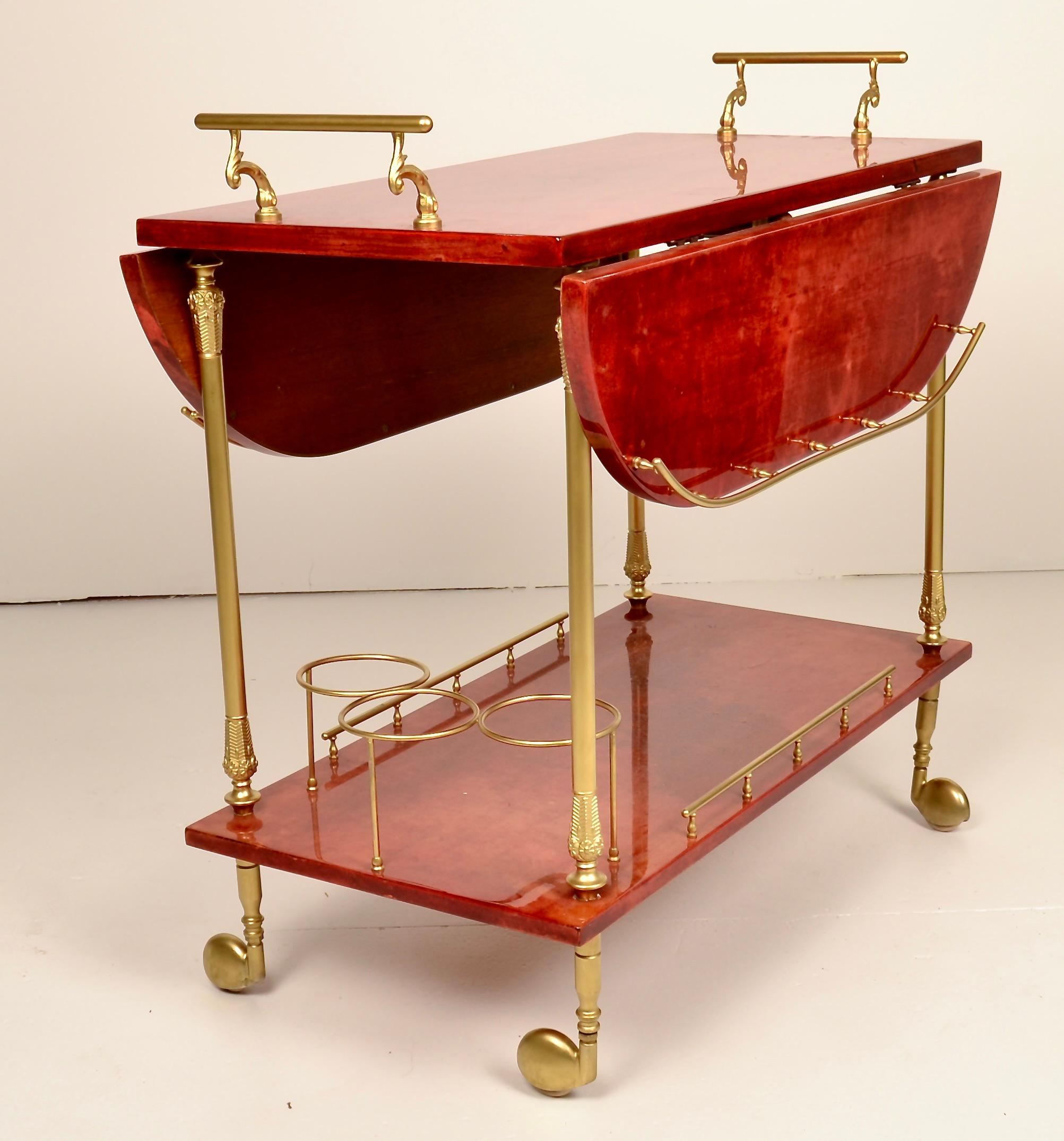 Such a great color on this Aldo Tura bar cart crafted from Tura's signature lacquered goat skin with gold tone hardware. This example features drop down sides that, when raised expand to a width of 30.75