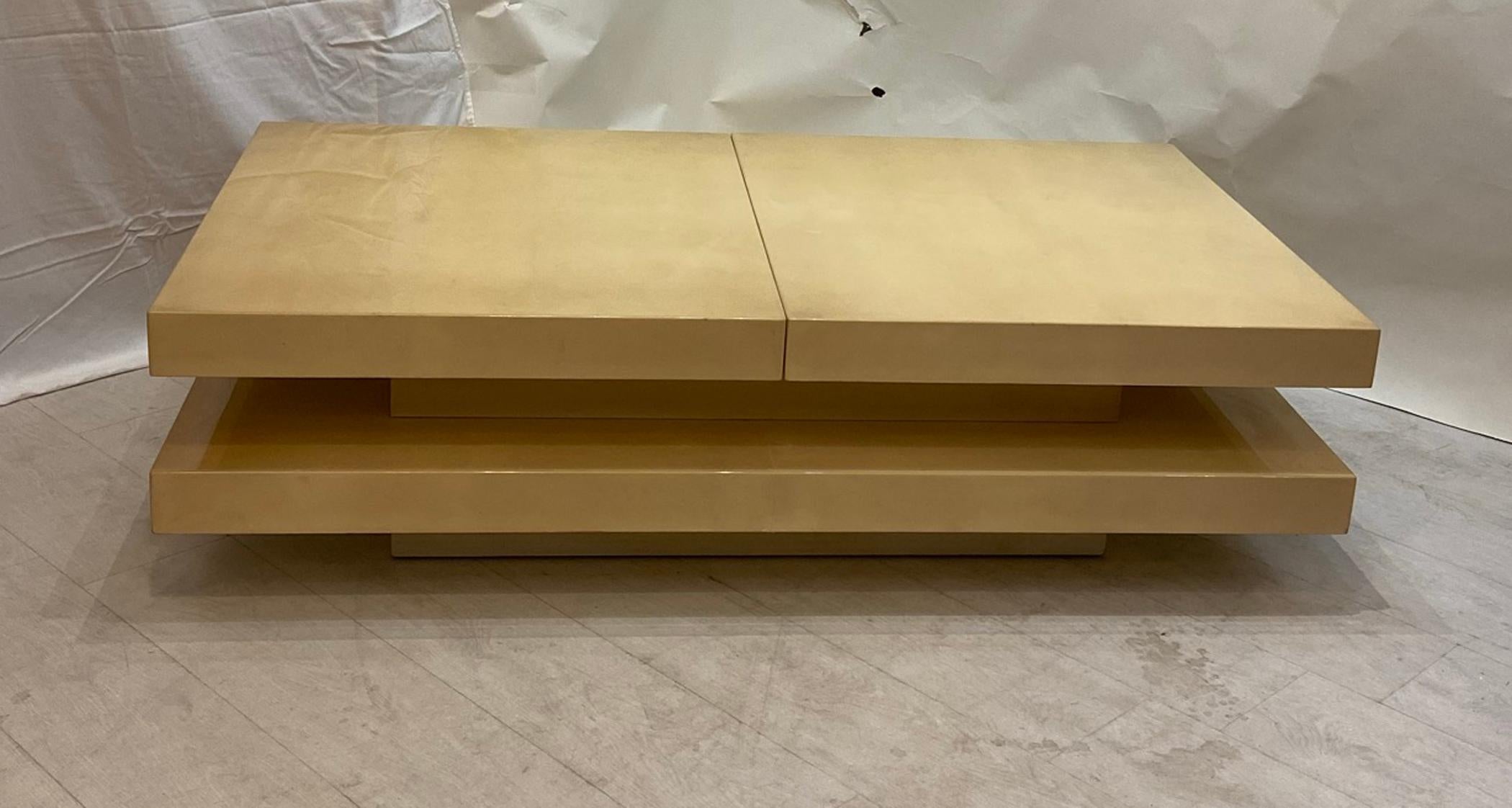 Two-tier Aldo Tura natural colored lacquered parchment coffee table. Top opens to reveal deep mirrored bar / storage 15.25 high, 31.5 deep by 55 wide. When opened 75.25 wide. In very good original condition.