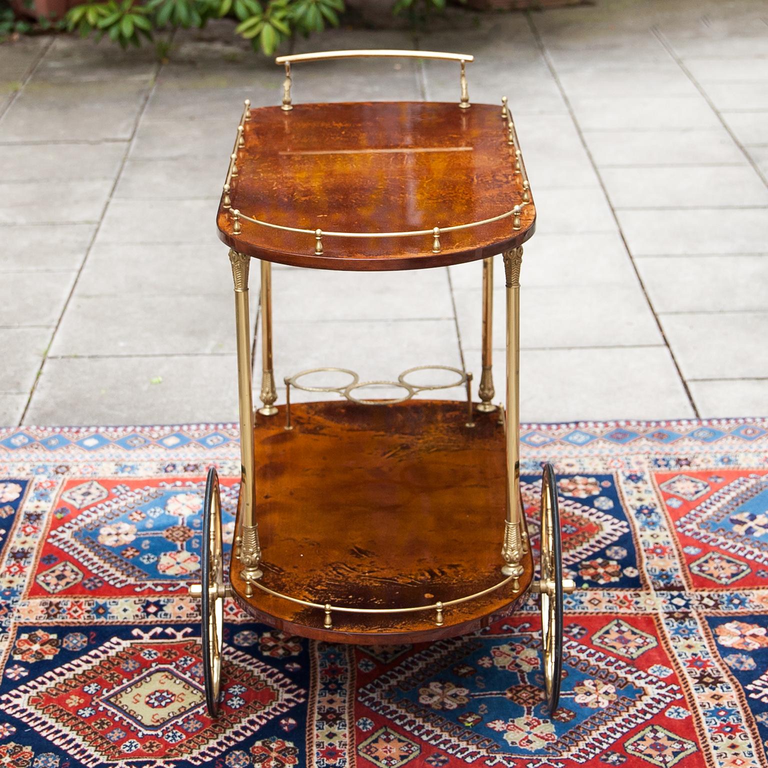 Aldo Tura bar cart lacquered in light brown with golden brass applications and a bottle holder. This particular bar cart was executed, circa 1960 and is in excellent vintage condition. The surface was new polished and has no scratches on the