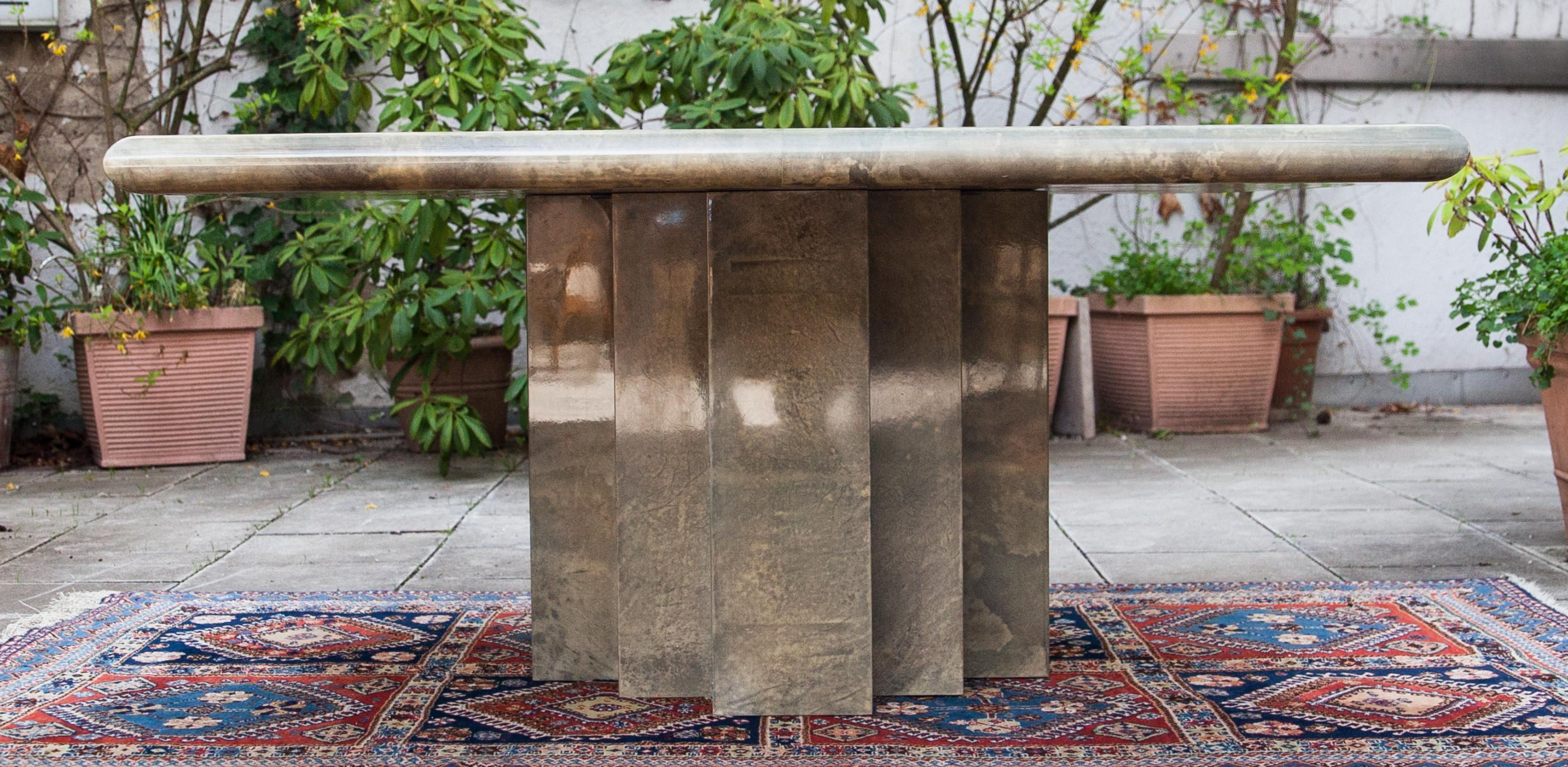 Der elegante quadratische Esstisch Aldo Tura aus Pergament basiert auf dem ikonischen achteckigen Säulengestell. Dieser Esstisch wurde in den 1970er Jahren gefertigt und ist in ausgezeichnetem Zustand.
Zusammen mit Künstlern wie Piero Fornasetti