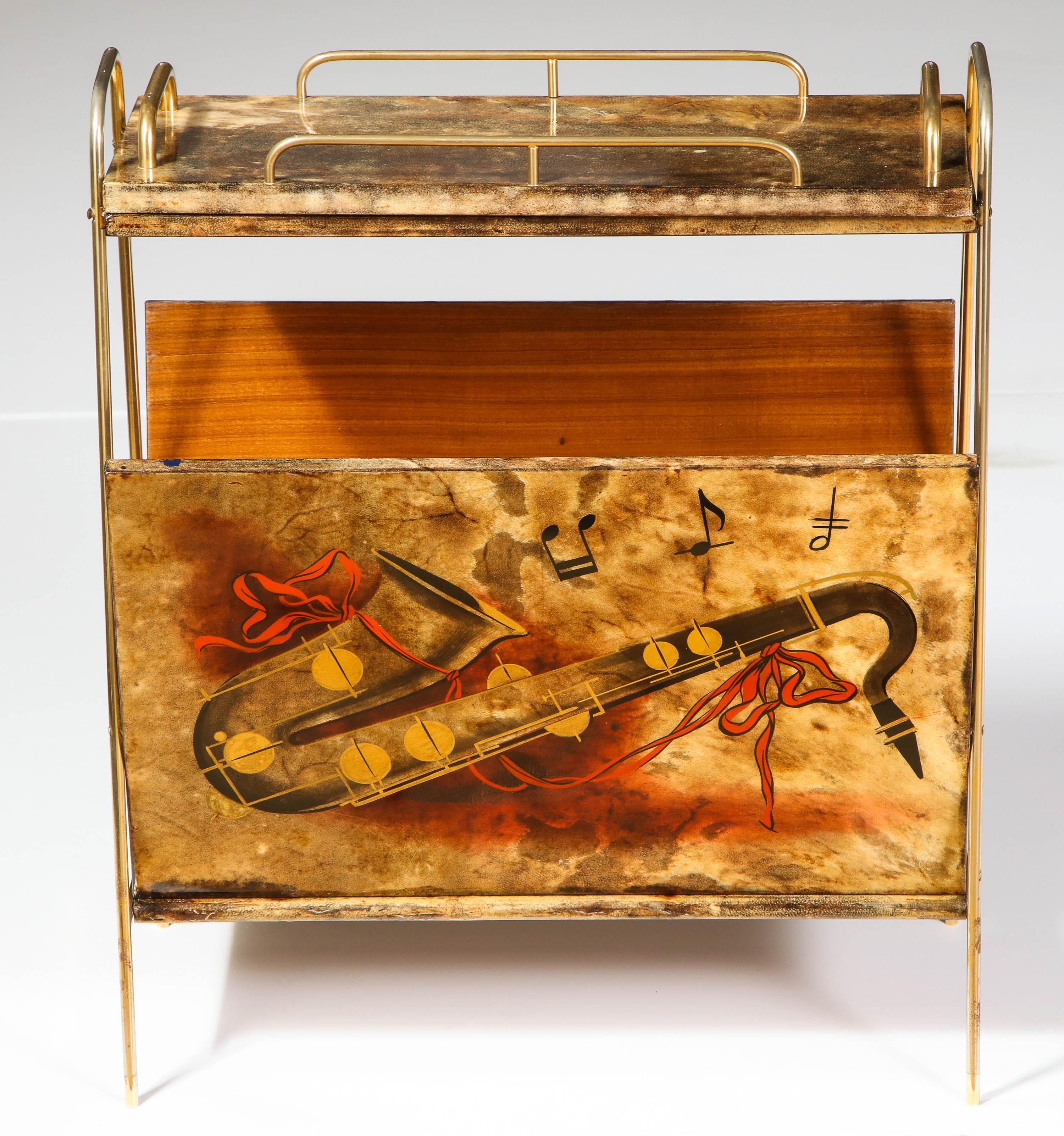 A very unusual magazine stand by Aldo Tura, Italy, midcentury, circa 1950, for sheet music.
Wood covered by goat skin parchment. The magazine stand has beautiful paintings on each side with musical instruments. Handles and legs are made of brass.