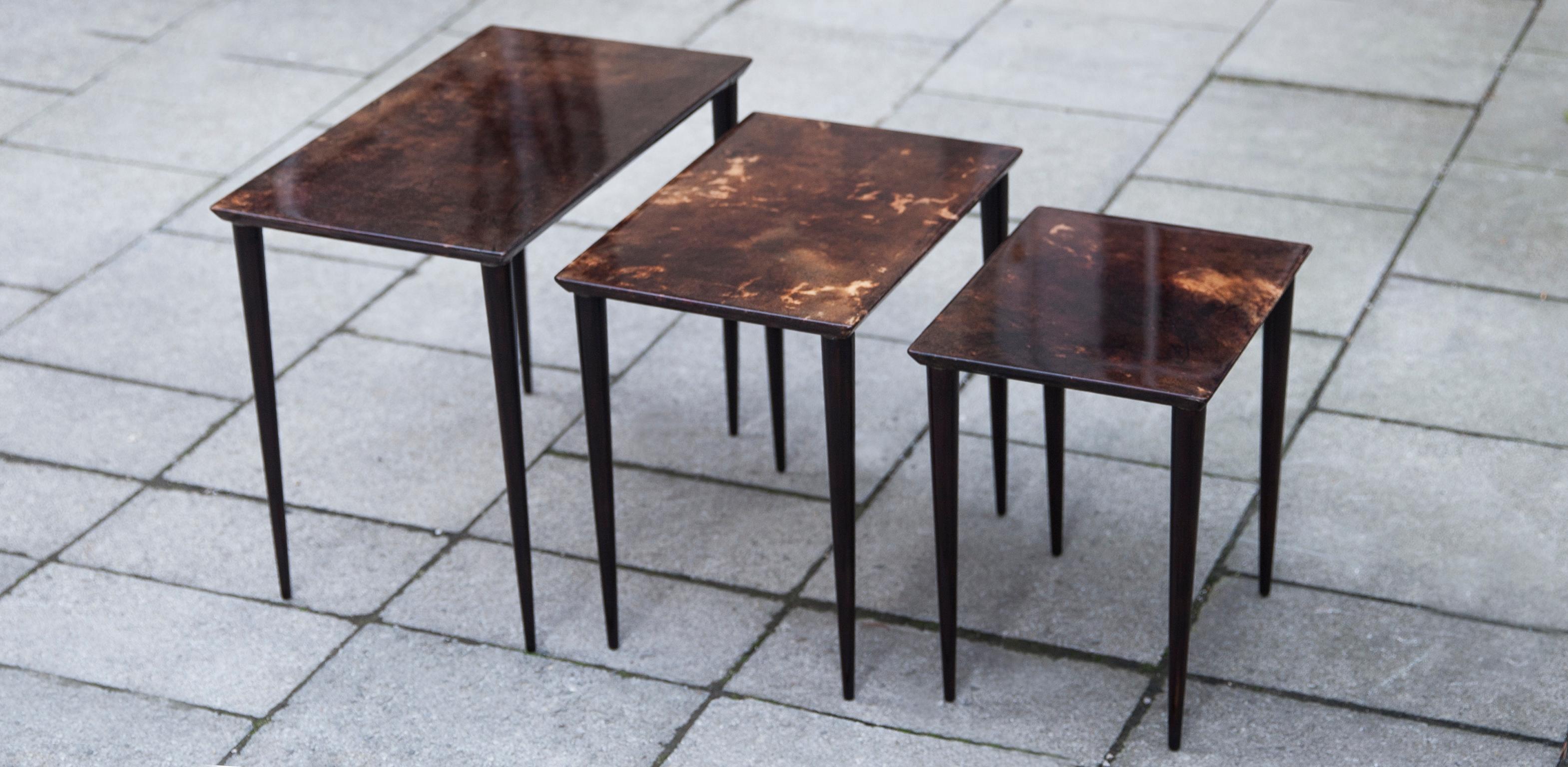 Set of three Aldo Tura nesting tables in lacquered goatskin and tanned pearwood legs. This particular set was executed, circa 1960 and is in perfect condition. Along with artists like Piero Fornasetti and Carlo Bugatti, Aldo Tura (1909-1963)