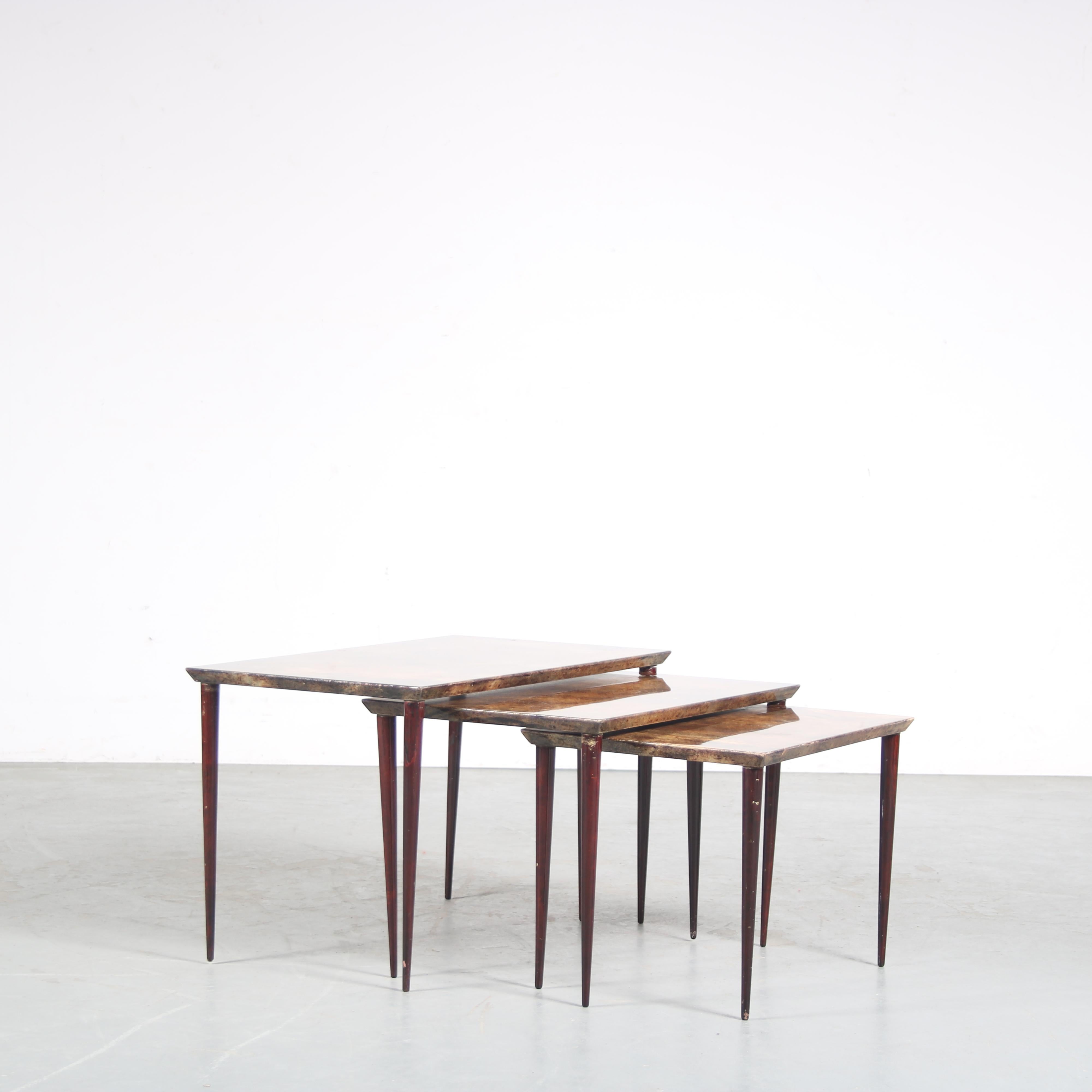A beautiful set of three nesting tables, designed by Aldo Tura in Italy around 1950.

The tables are all made of high quality deep brown wood with parchments tops, giving them a unique and highly recognizable style. The tables are beautifully