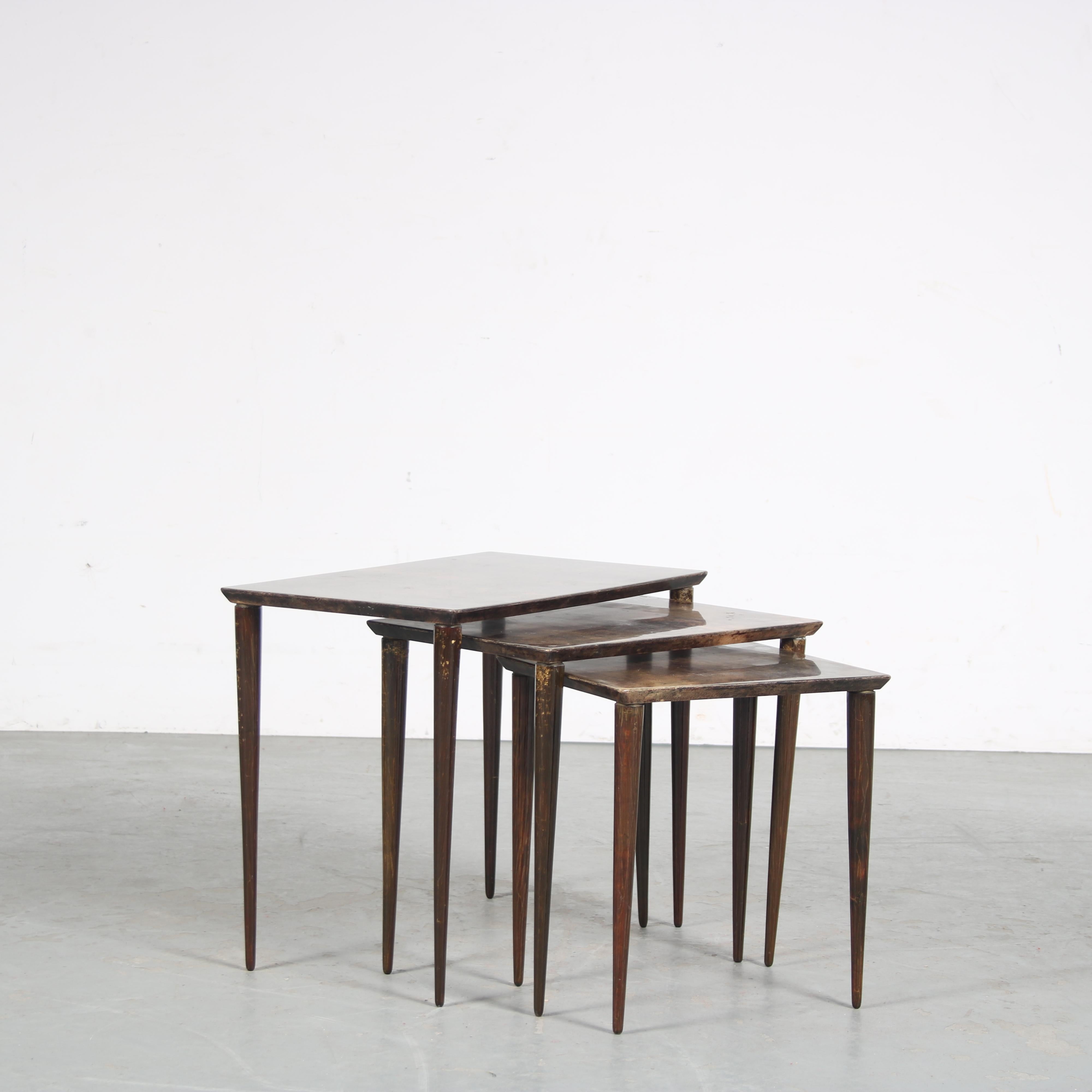 A beautiful set of three nesting tables, designed by Aldo Tura in Italy around 1950.

The tables are all made of high quality deep brown wood with parchments tops, giving them a unique and highly recognizable style. The tables are beautifully