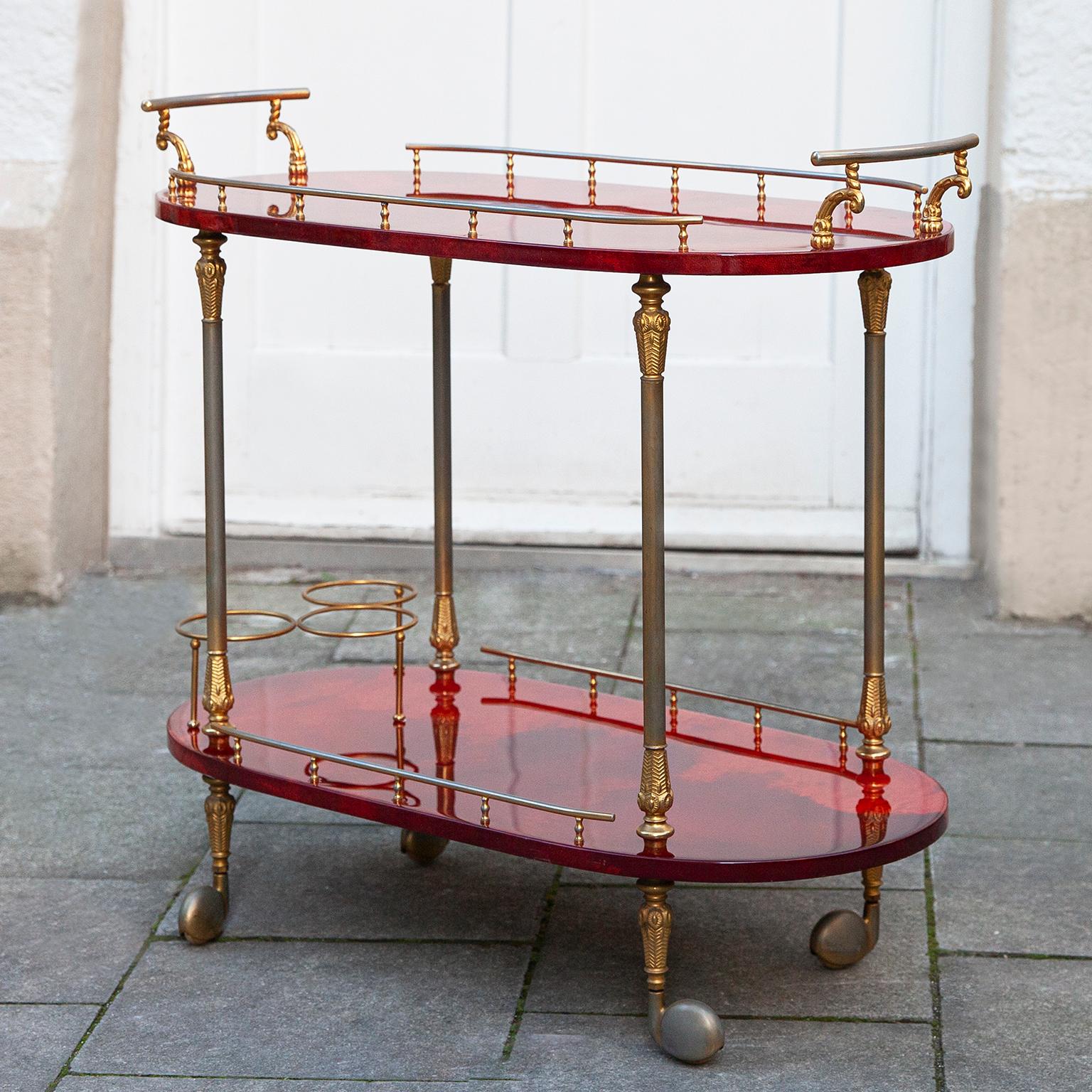 Wonderful bar cart made by Aldo Tura,Italy in the 1960s.

The bar cart was executed in lacquered red goatskin with brass applications and includes a bottle holder and it is in nearly excellent condition.

Along with artists like Piero Fornasetti