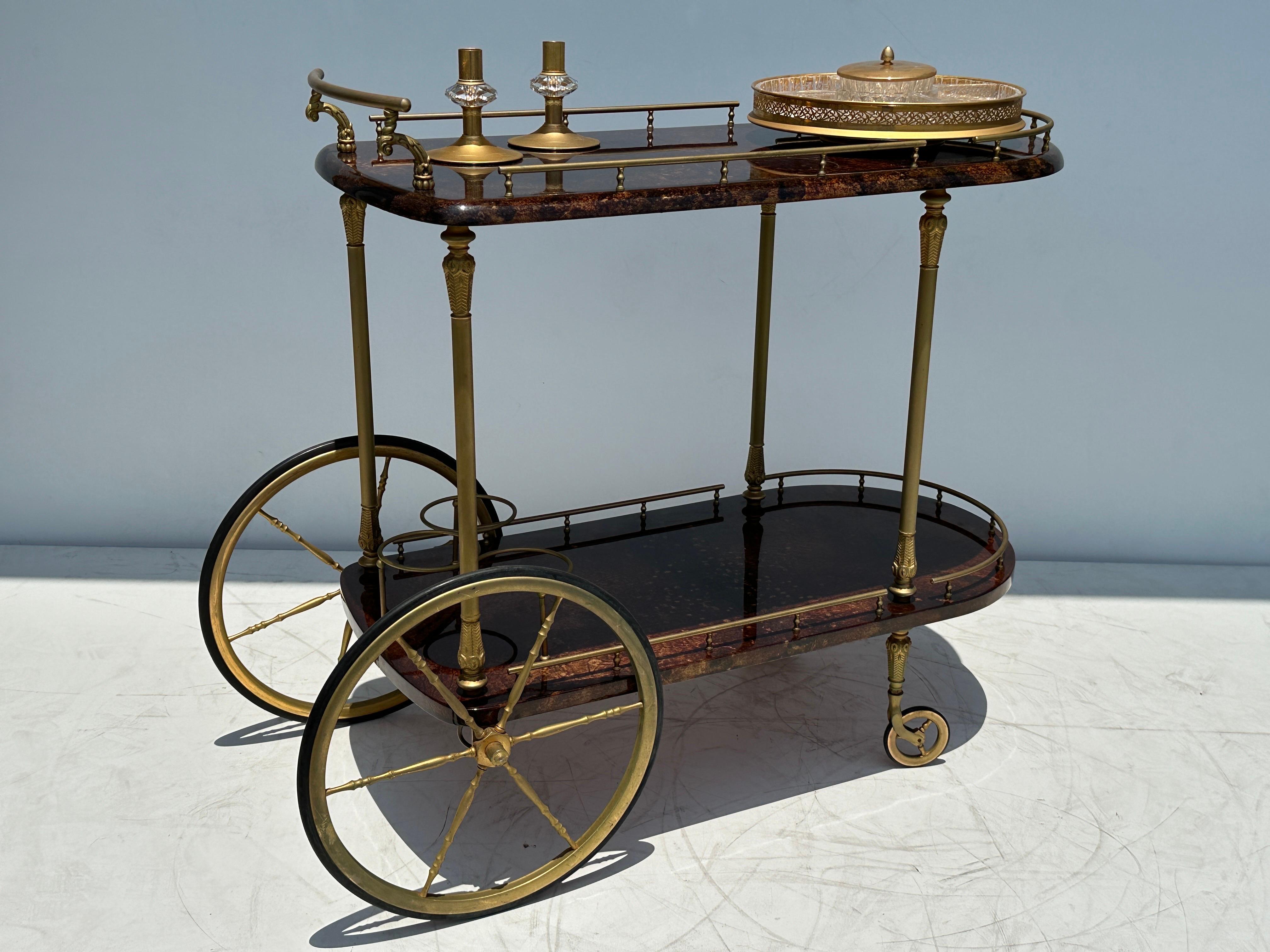 Chariot de bar en parchemin brun Aldo Tura avec plat pivotant en cristal pour bonbons/noisettes et chandeliers assortis.
Quelques petites éraflures sur le parchemin, ce qui est normal pour son âge.