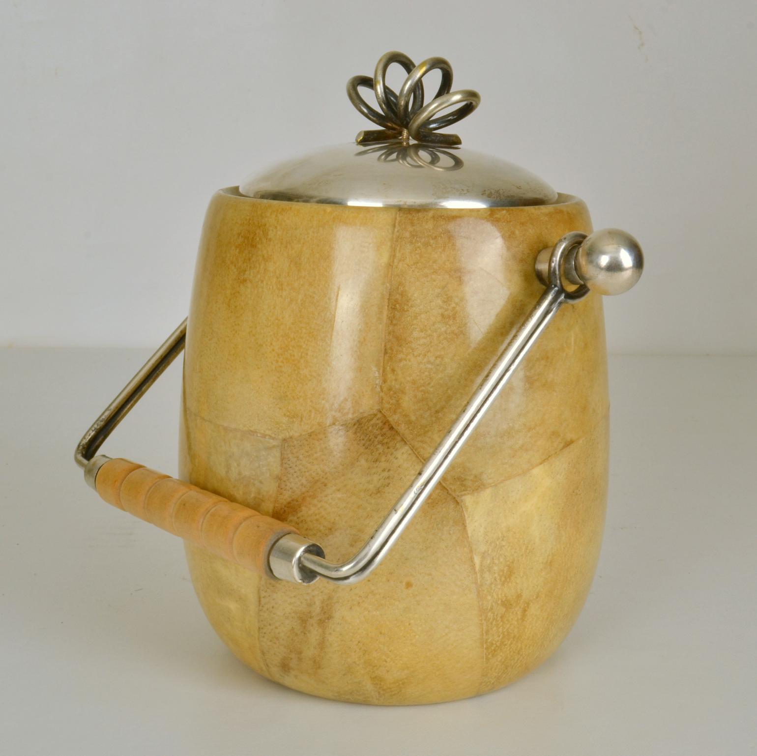 Early Aldo Tura ice bucket in a light cream tanned parchment, nickel plated bras and wooden handle and spoon made in the late 1940's Italy.
Aldo Tura (1909-1963) focused on applying a specific material like lacquered goatskin on furniture and