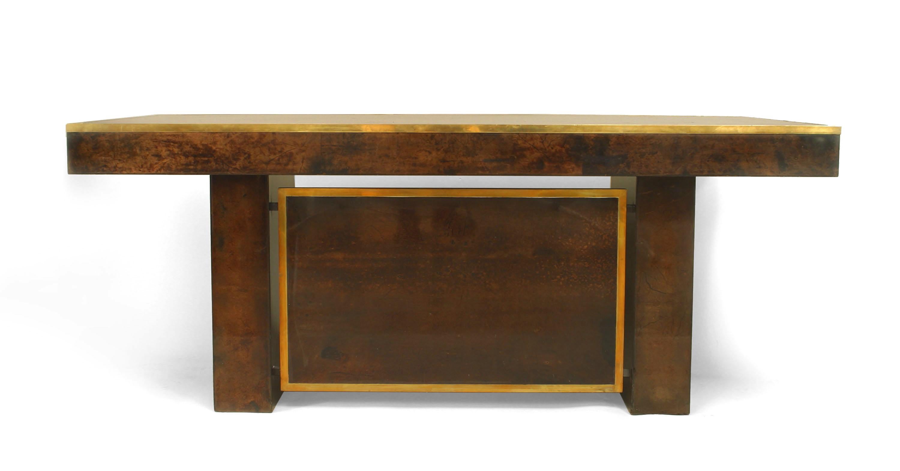 Italian 1940/1950s brown parchment veneer desk with brass trimmed edge and 4 drawers supported on 2 rectangular pedestals with a vanity panel. (ALDO TURA)
