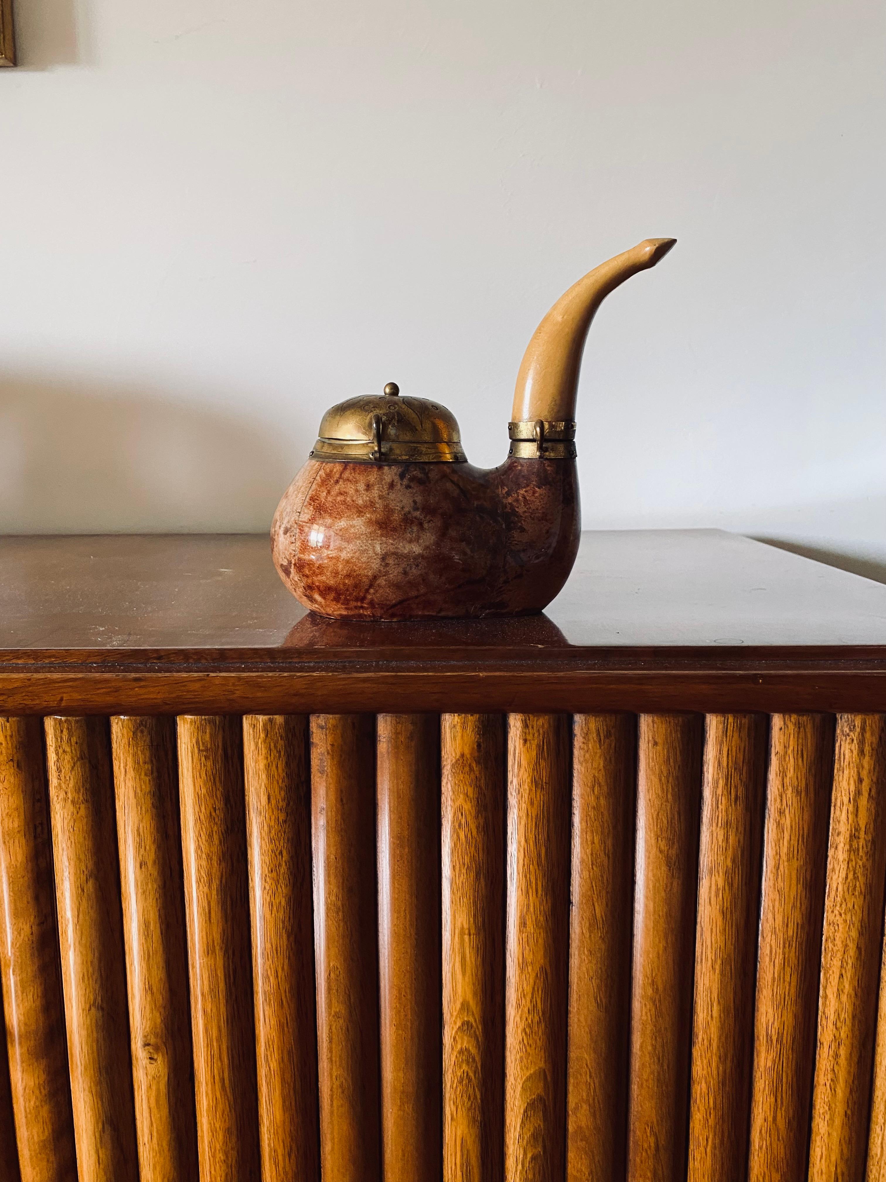 Pipe shaped parchment and brass tobacco box designed by Aldo Tura

Macabo Italy 1950s

The box has two compartments, one for storing tobacco and another for storing and lighting matches.

Goatskin parchment, brass, wood

Marked on the