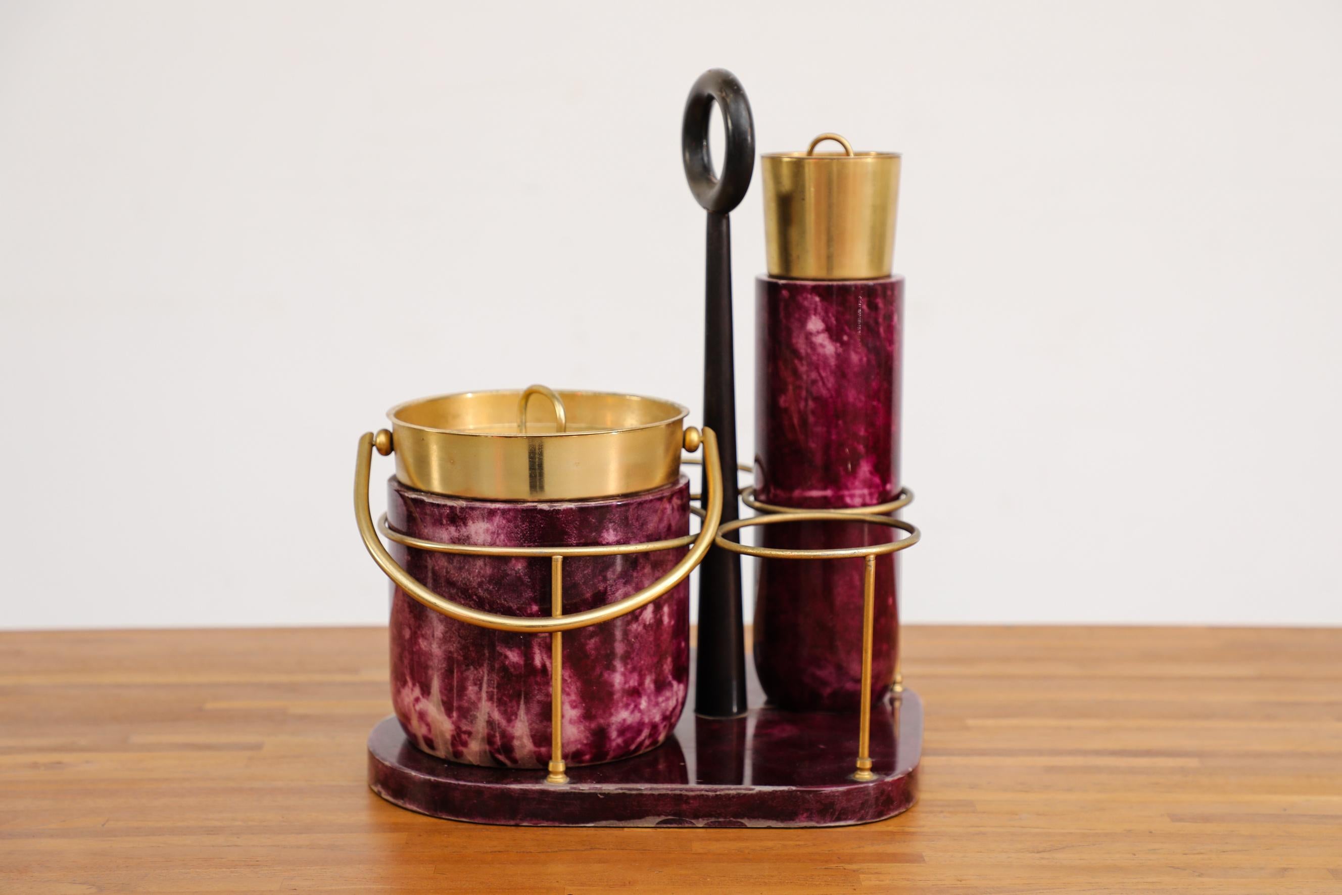 1970's Aldo Tura Cocktail Set with carrier, ice bucket, and cocktail shaker in purple dyed goat skin and brass. Tura focused almost exclusively on lacquered goatskin, applying it to an array of glamorous products for the home. Chocolate brown is