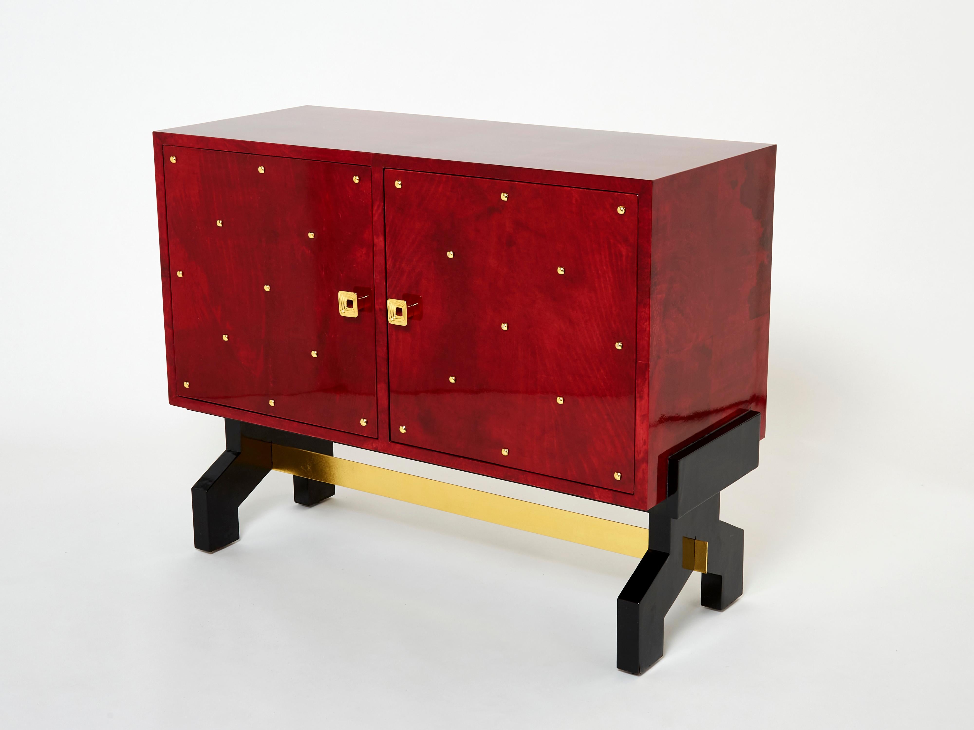 A unique and timeless vintage piece, this Aldo Tura midcentury cabinet bar feels imposing and glamorous. The varnished goatskin parchment, in rich shades of red, makes this cabinet typical of designer Aldo Tura. Its boxy style, featuring two doors