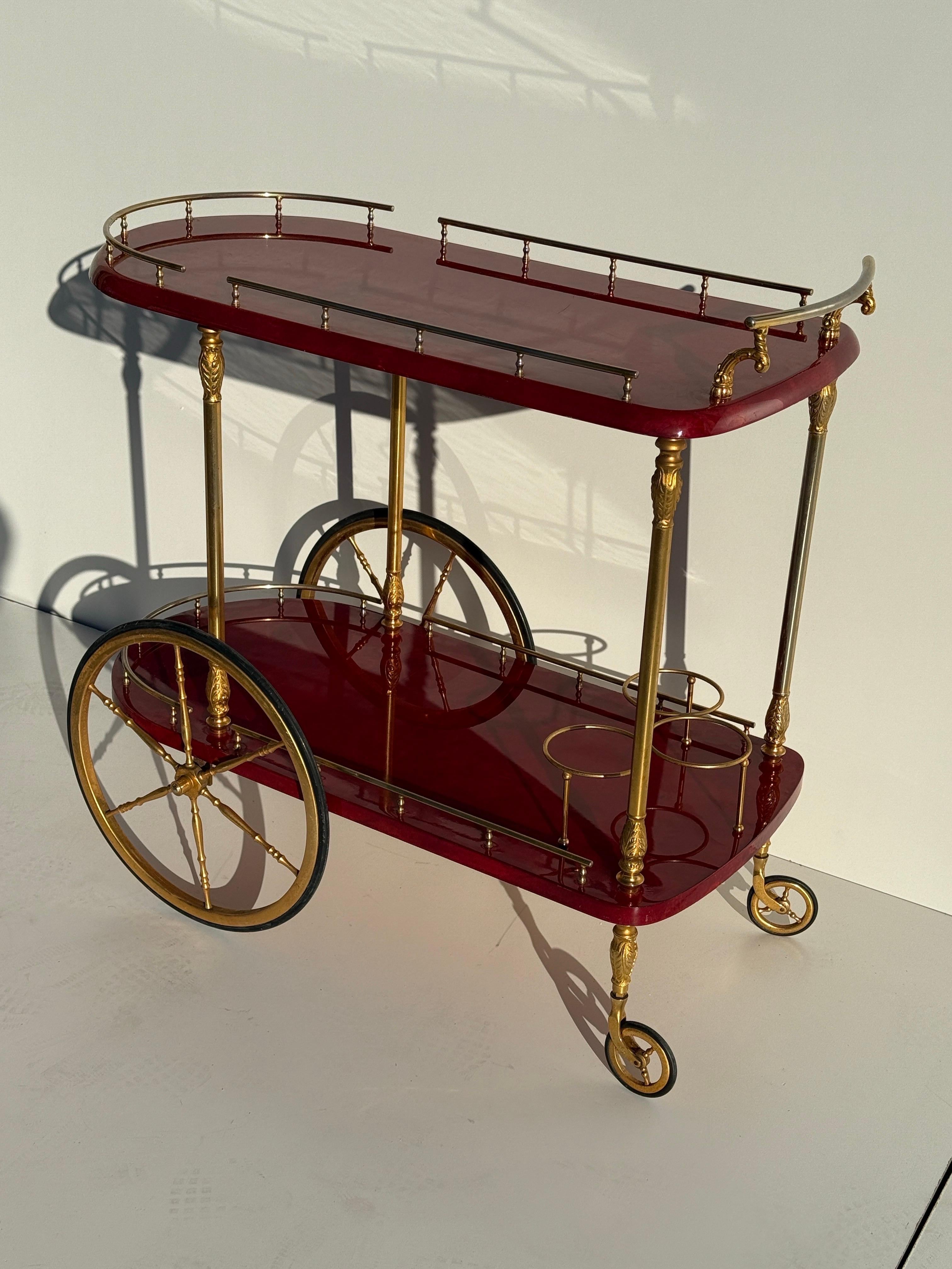 Aldo Tura red parchment bar cart.
Light scuffs on parchment and some brass finish loss on handle.