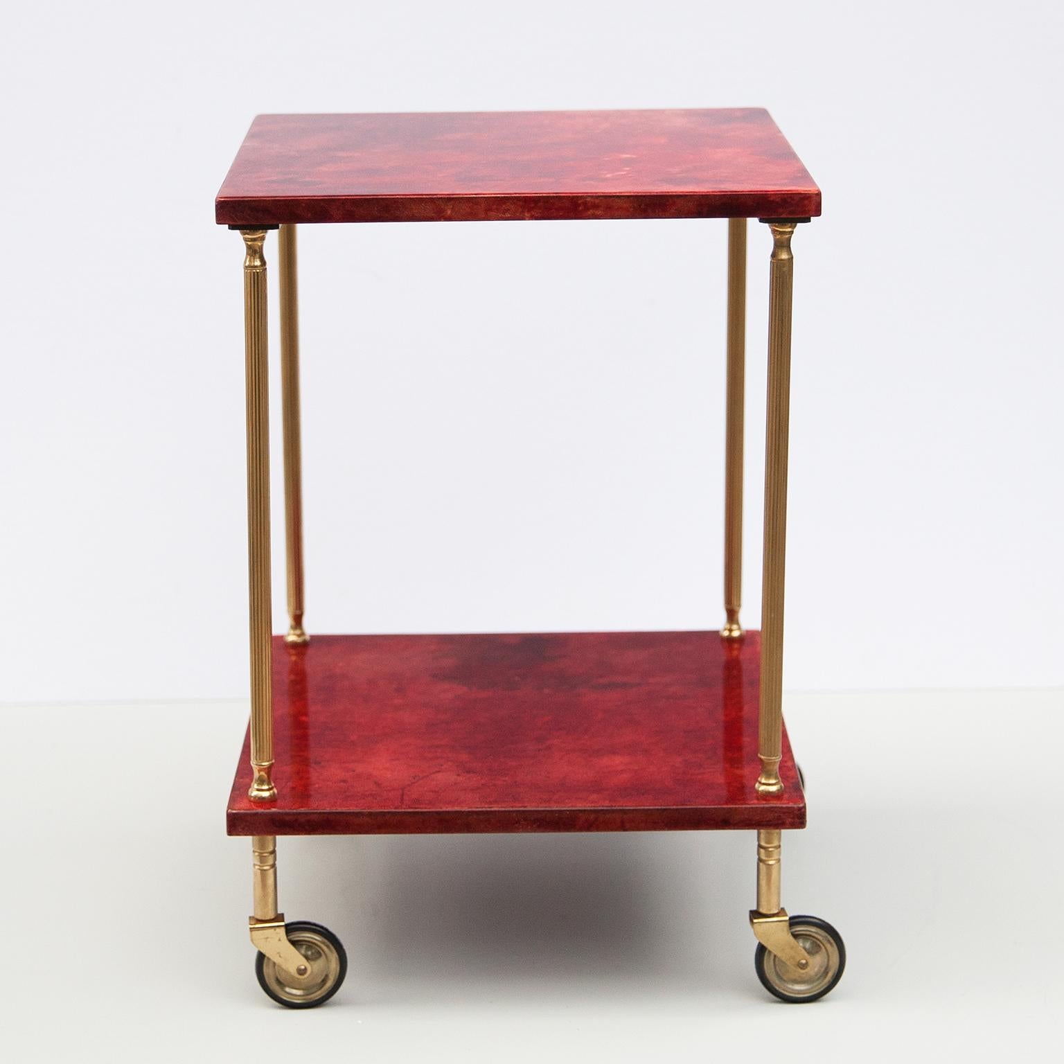 Wonderful bar cart of Aldo Tura in lacquered goatskin with brass rods and is in very good vintage condition.
This serving cart was executed, circa 1960 in a red parchment. Along with artists like Piero Fornasetti and Carlo Bugatti, Aldo Tura