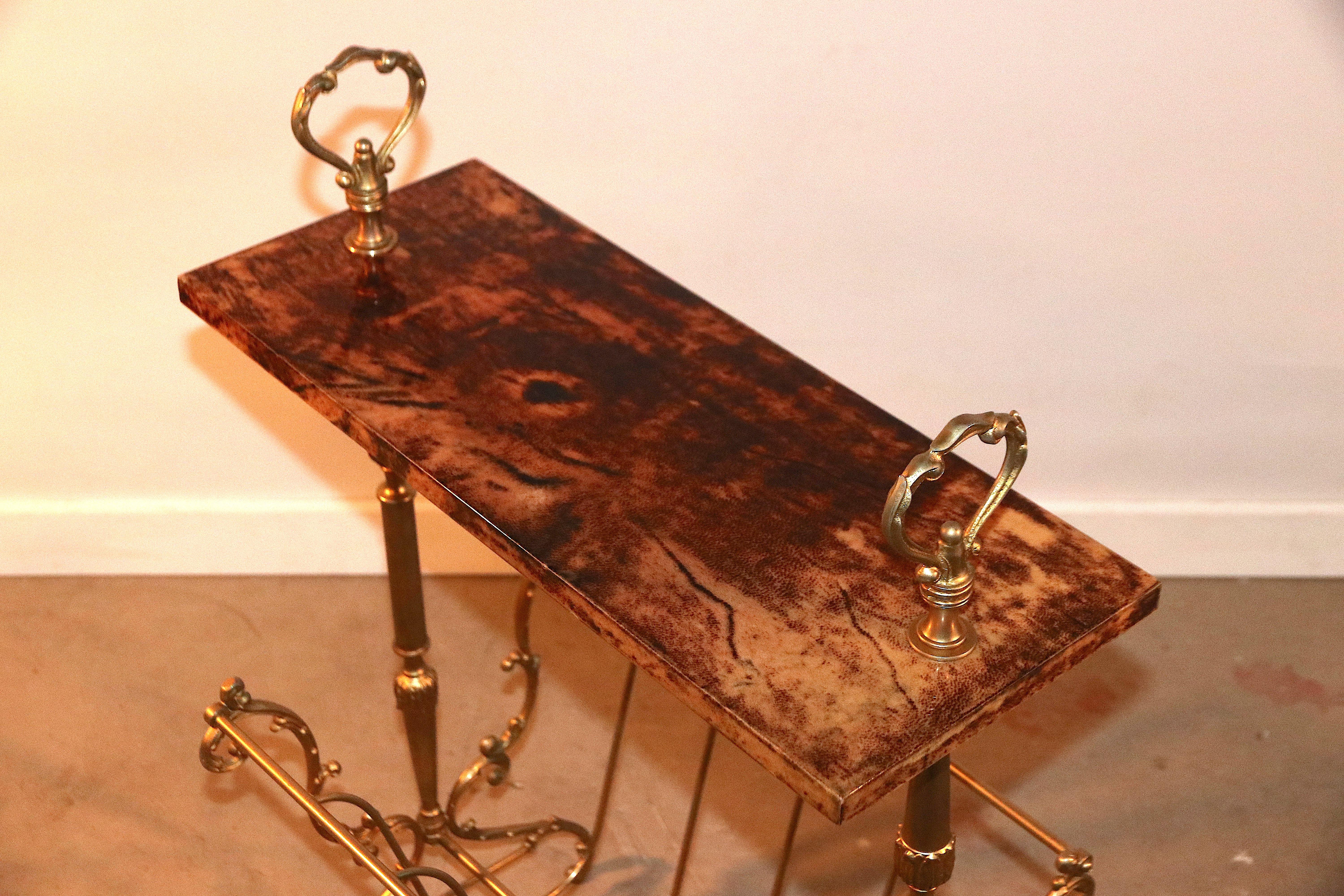 This is a beautiful and rare gold-colored side table and magazine rack designed by Aldo Tura. The piece is covered with Tura's signature material 