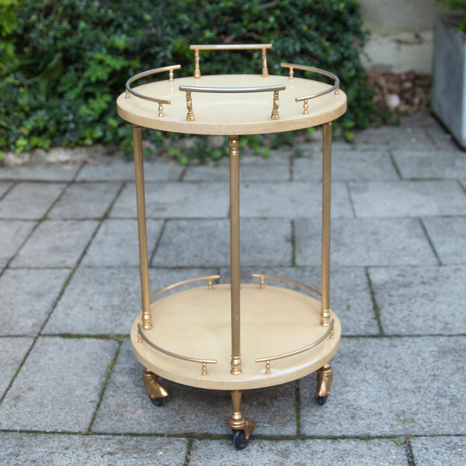 Round serving cart with brass applications made by Aldo Tura in the 1960s.
This particular bar cart was executed, circa 1960 and is in very good condition. Along with artists like Piero Fornasetti and Carlo Bugatti, Aldo Tura (1909-1963) definitely