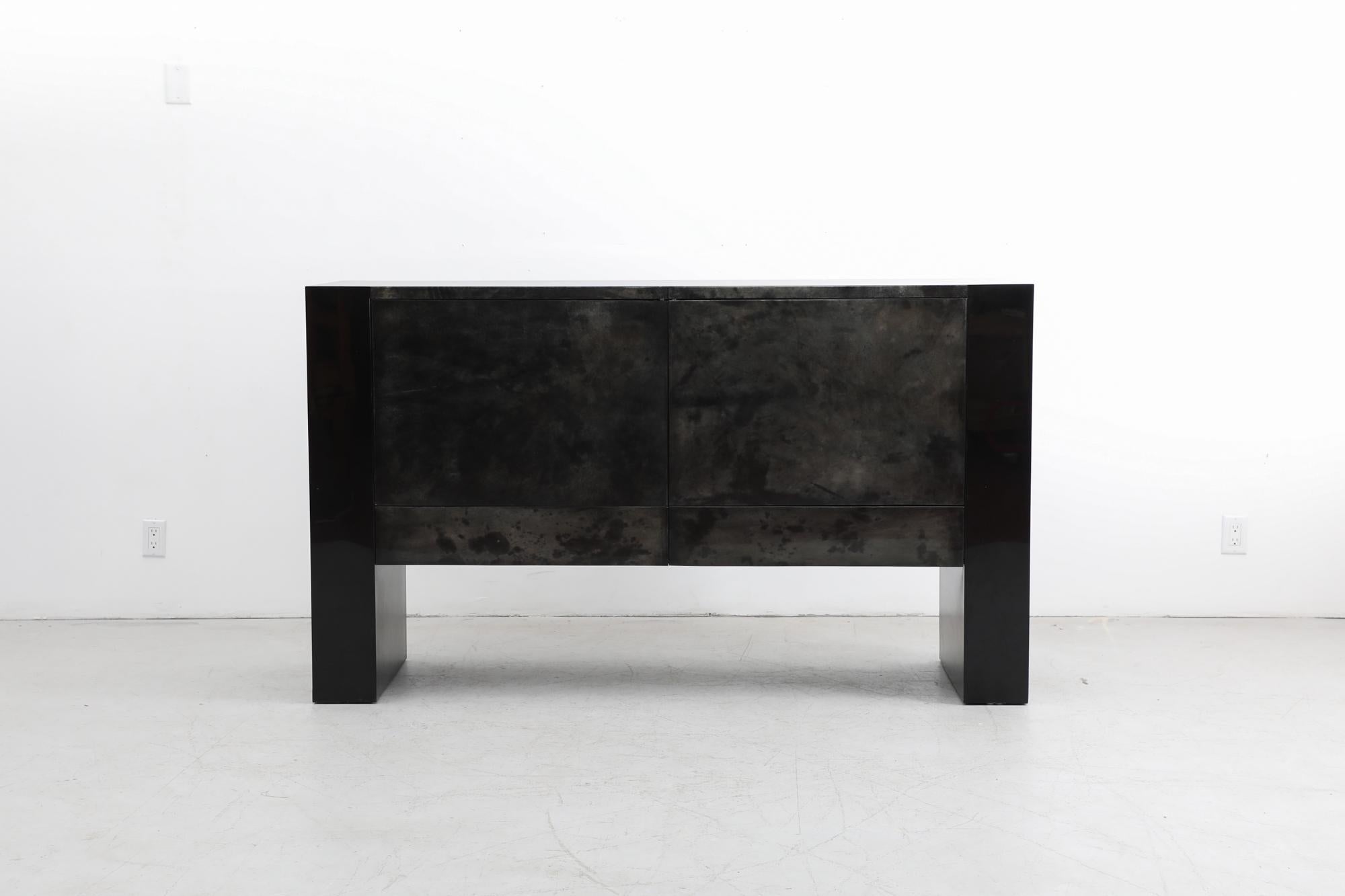 Special Aldo Tura style dark charcoal-greenish goatskin parchment covered sideboard with black lacquered sides. This credenza has double doors over two lower drawers. The cabinets have room for shelves, but have been removed by it's previous owner.