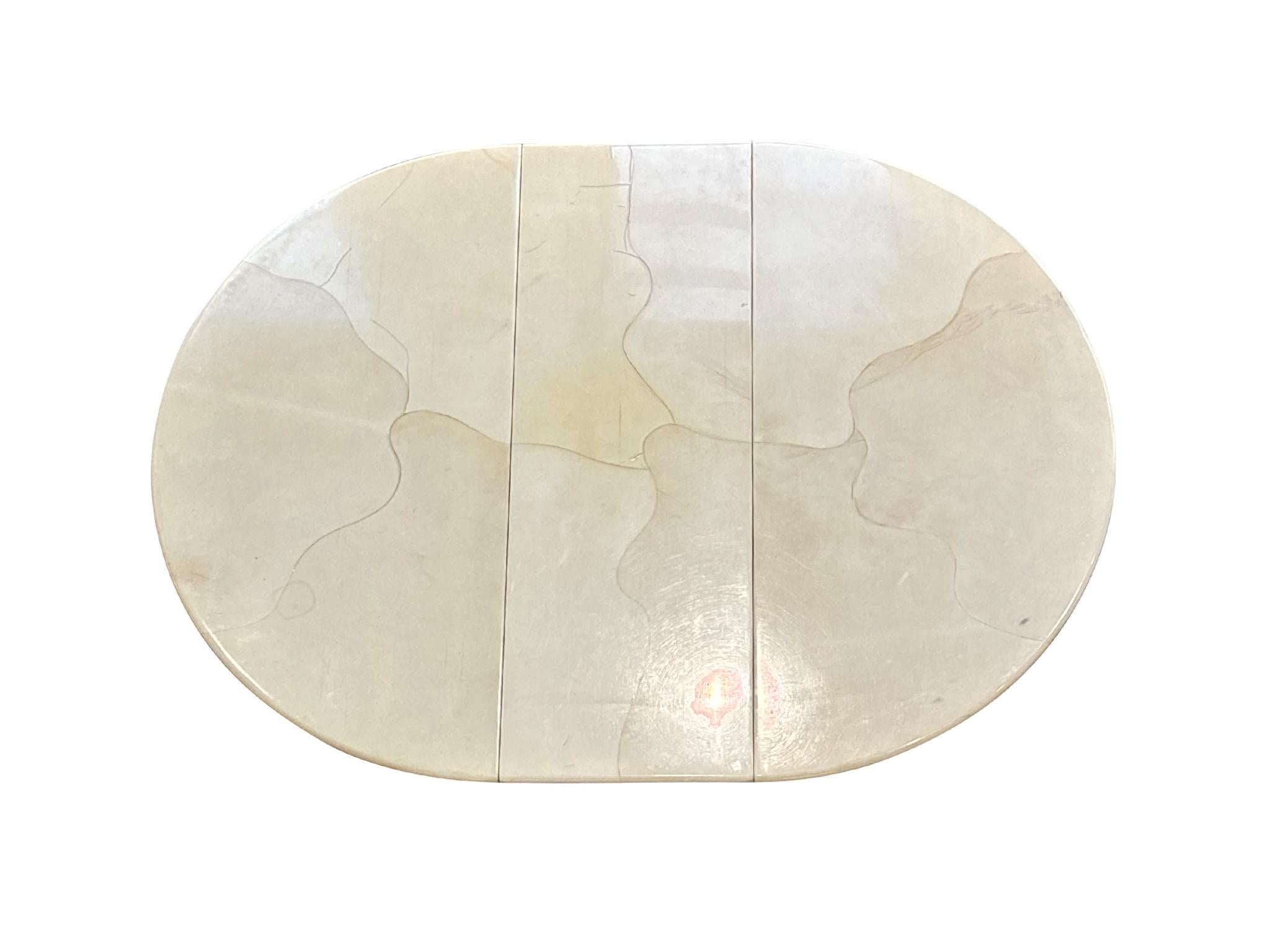 This Mid-20th century lacquered goatskin dining table was made in the style of Italian furniture designer Aldo Tura, renowned for his use of unconventional materials. This table may be simple in silhouette, but it stands out for its complex