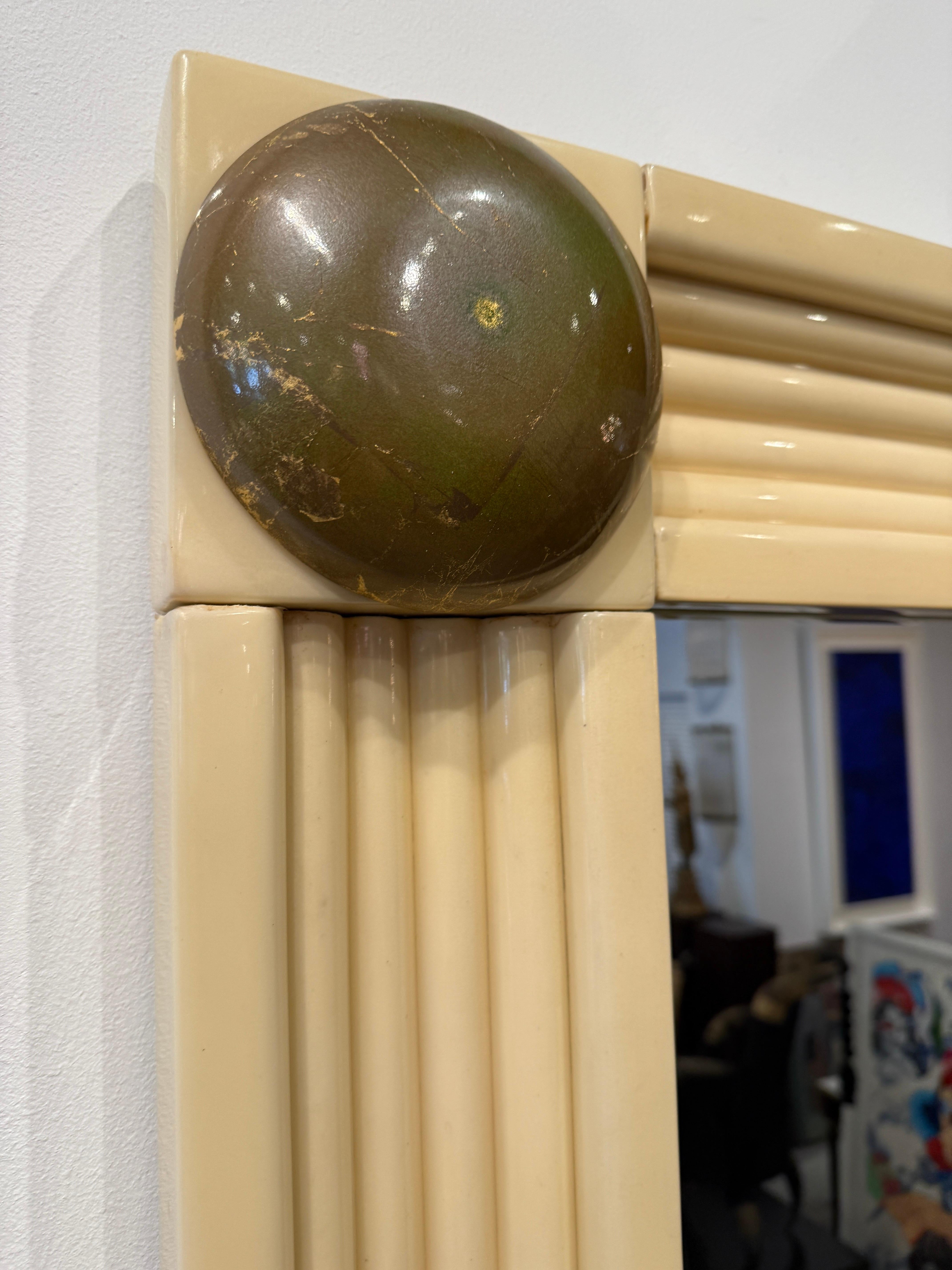 This channeled lacquered goatskin clad frame is consistent in color throughout.  One of the medallion accents is a little lighter than the others but does not affect the natural vintage beauty of this large scale mirror.  