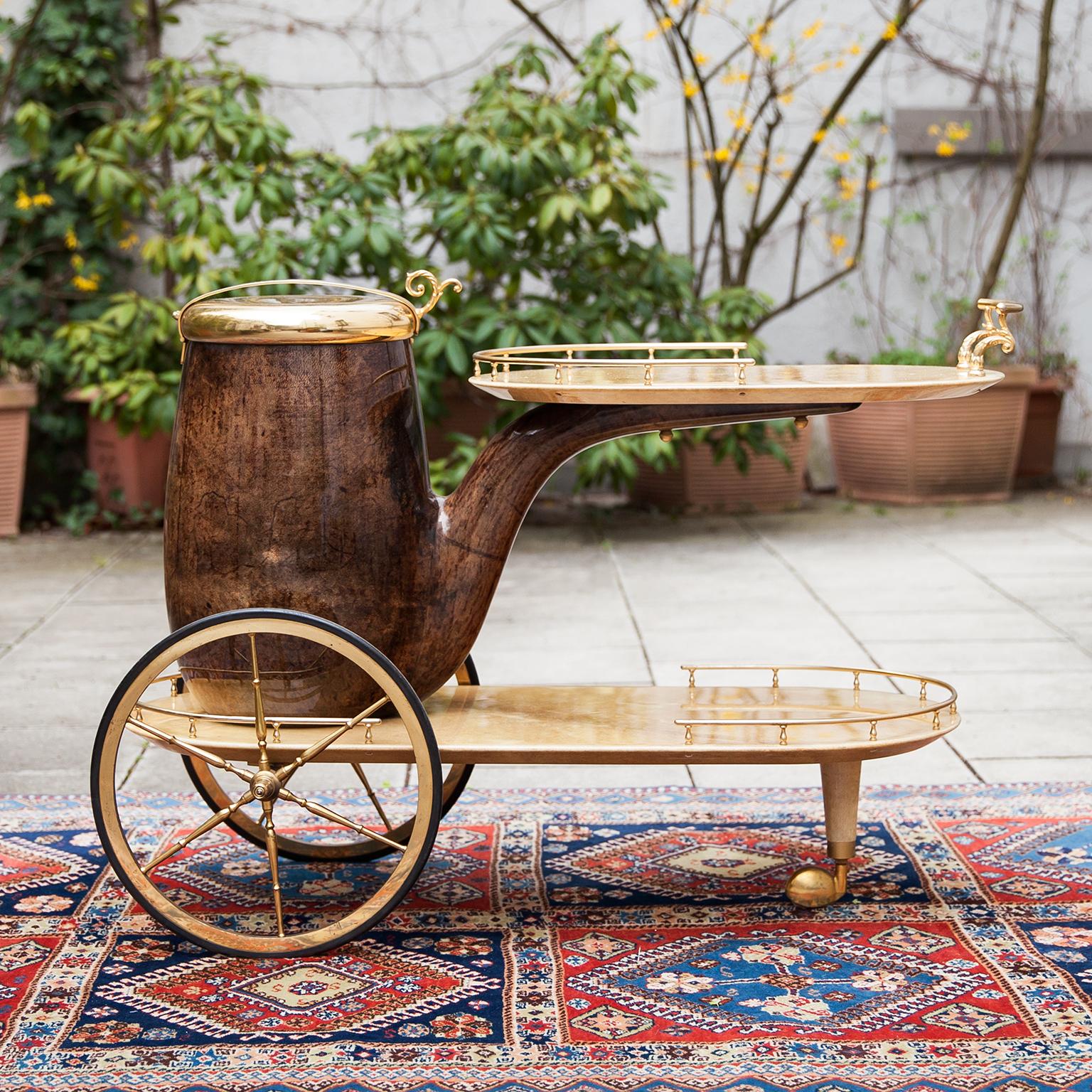 Aldo Tura bar cart in form of a pipe, lacquered in brown and cream goatskin with golden brass applications and a huge container as champagne or wine cooler.
This particular bar cart was executed, circa 1960s and is in very good vintage condition.
