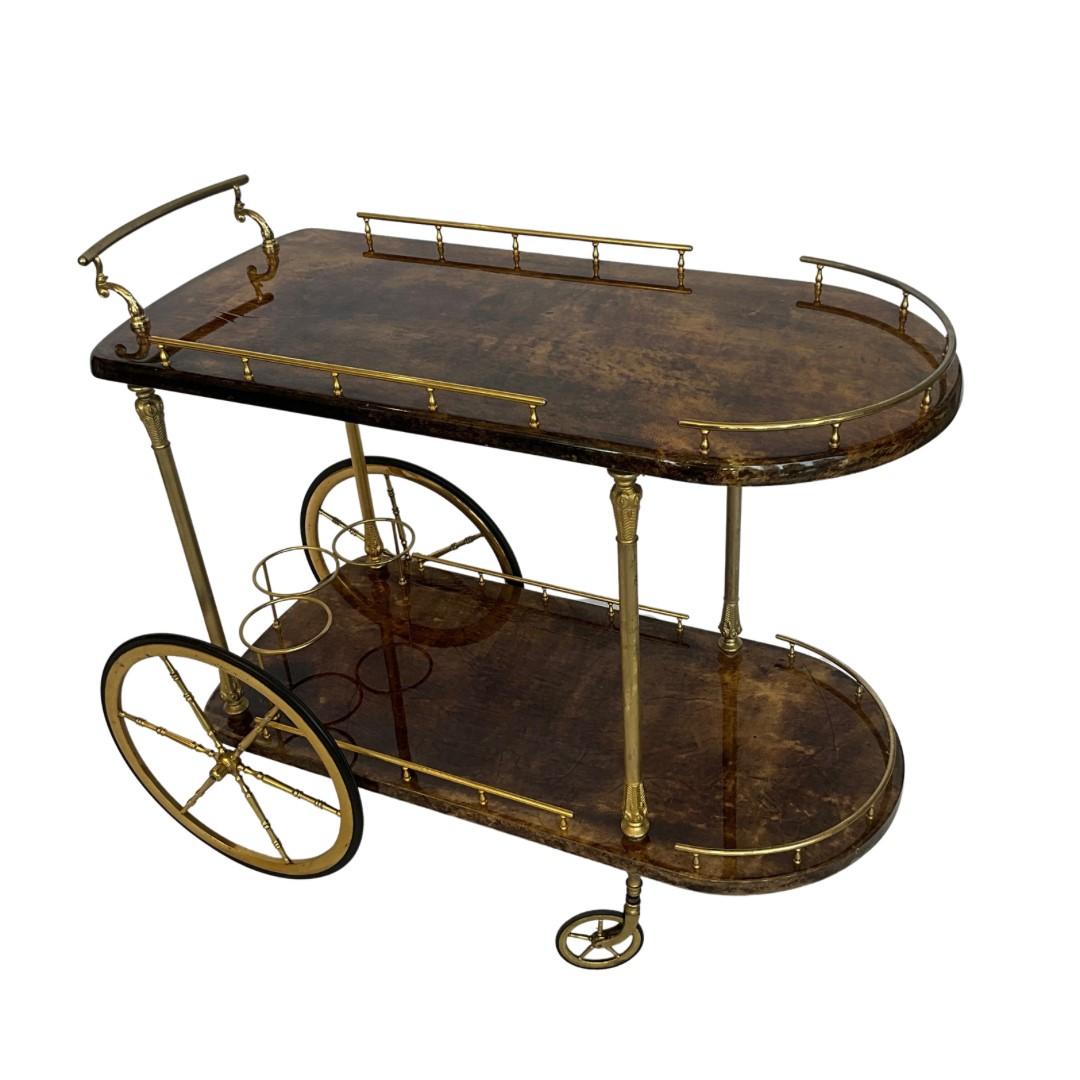 Aldo Tura

Italy

1960's

Oak Base Bar Cart with Lacquered Goat Skin & Brass Hardware

This is a 2-Tier Bar Cart with 2 Large Accent Wheels in the Back & Smaller Wheels in the Front

Brass Rail Guards & 3 Brass Bottle Holders