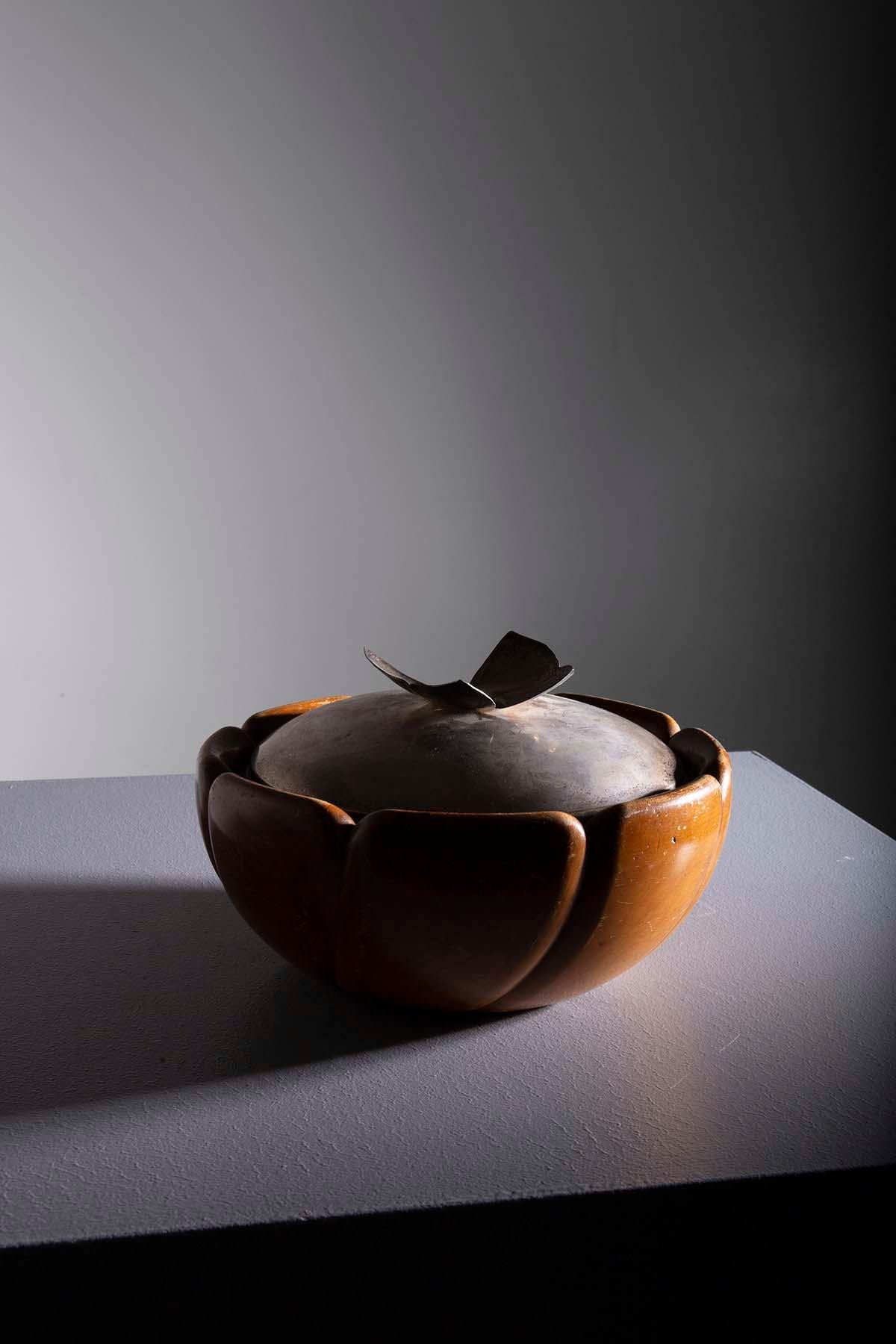 This extraordinary wooden bowl with a metal lid, created by Aldo Tura in the 1940s, is a timeless representation of Italian design. The lid features a butterfly-shaped handle, adding a touch of elegance and refinement to its design.

Aldo Tura was a