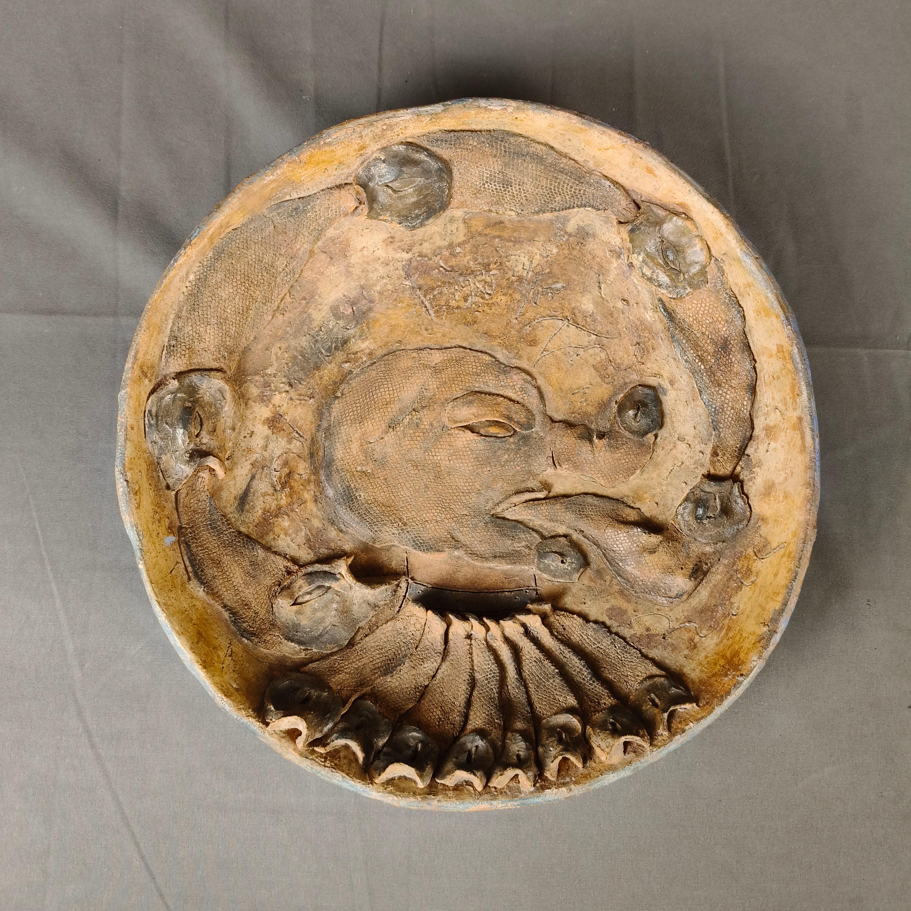 Une importante assiette en céramique de l'artiste mexicain Alejandro Colunga. Série 14 / 15. L'assiette est un assemblage de différentes pièces de céramique représentant des poissons et une tête de chien. Signé et daté 1980.

Alejandro Colunga (né