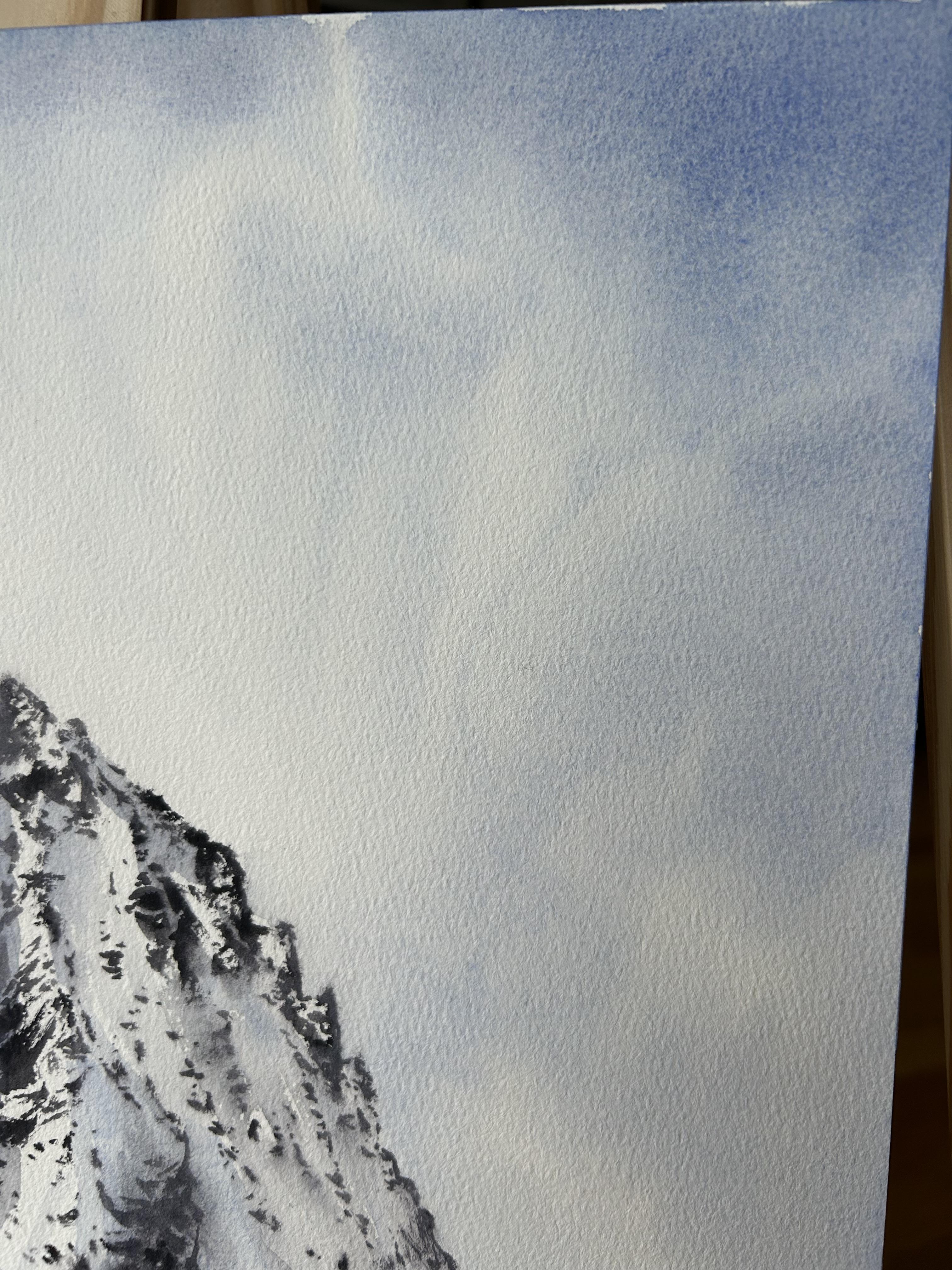Este paisaje pintado a la acuarela por Aleksandra Strokina presenta la esencia de un majestuoso pico de montaña que se eleva grácilmente hacia un cielo sereno. Los suaves tonos azules y blancos crean una atmósfera tranquila, mientras que los bordes