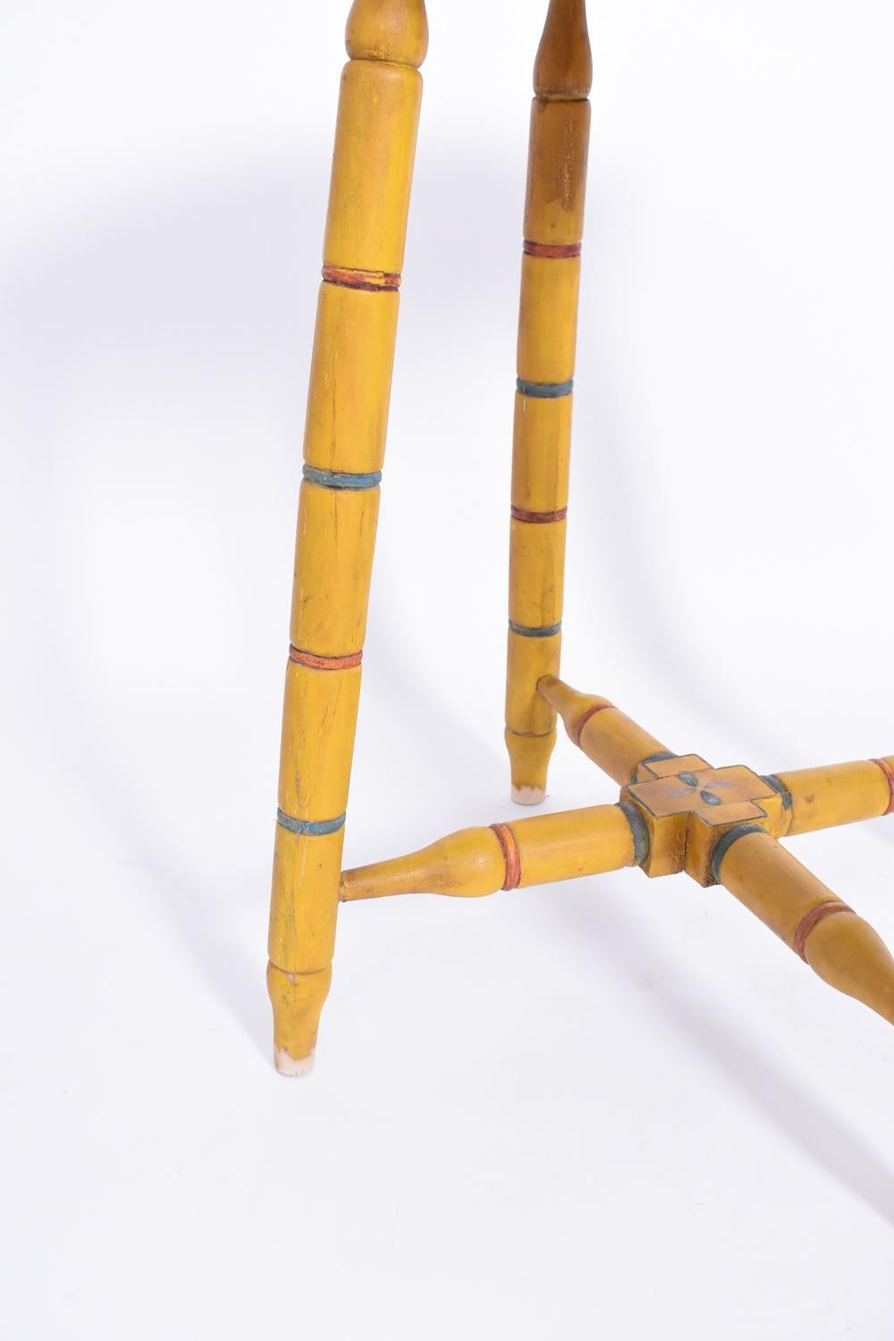 Alentejo folk art wooden yelllow painted round side table with a geometrical pattern standing on four feet joined by a cross spacer round side table. Portugal, 1950s.