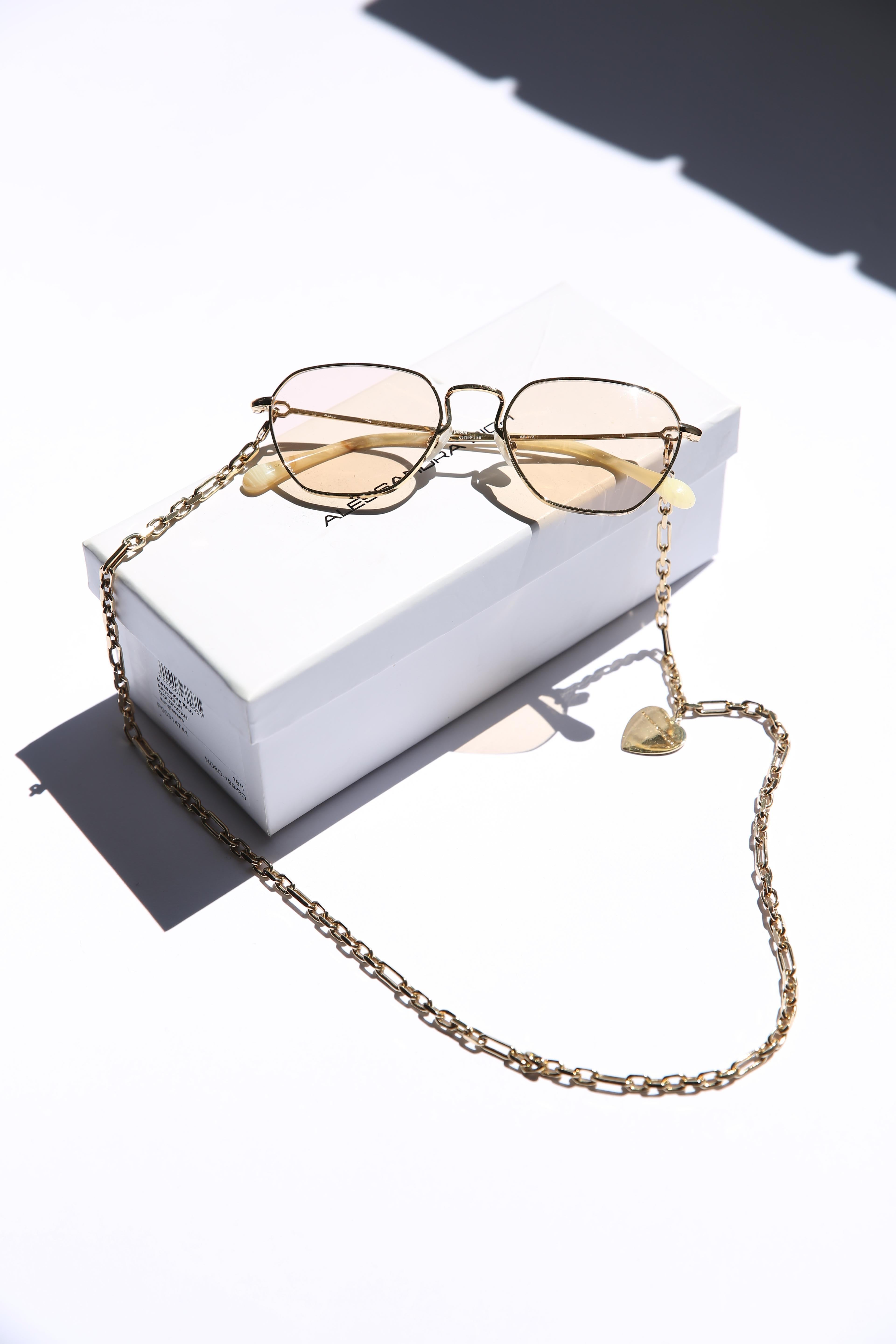 Alessandra Rich 1 C2 pink and yellow gold rectangular sunglasses with gold heart embellished chain

Charming collaboration designer Alessandra Rich's SS18 collection that perfectly balanced fine fabrics and chic silhouettes with kitschy details. The