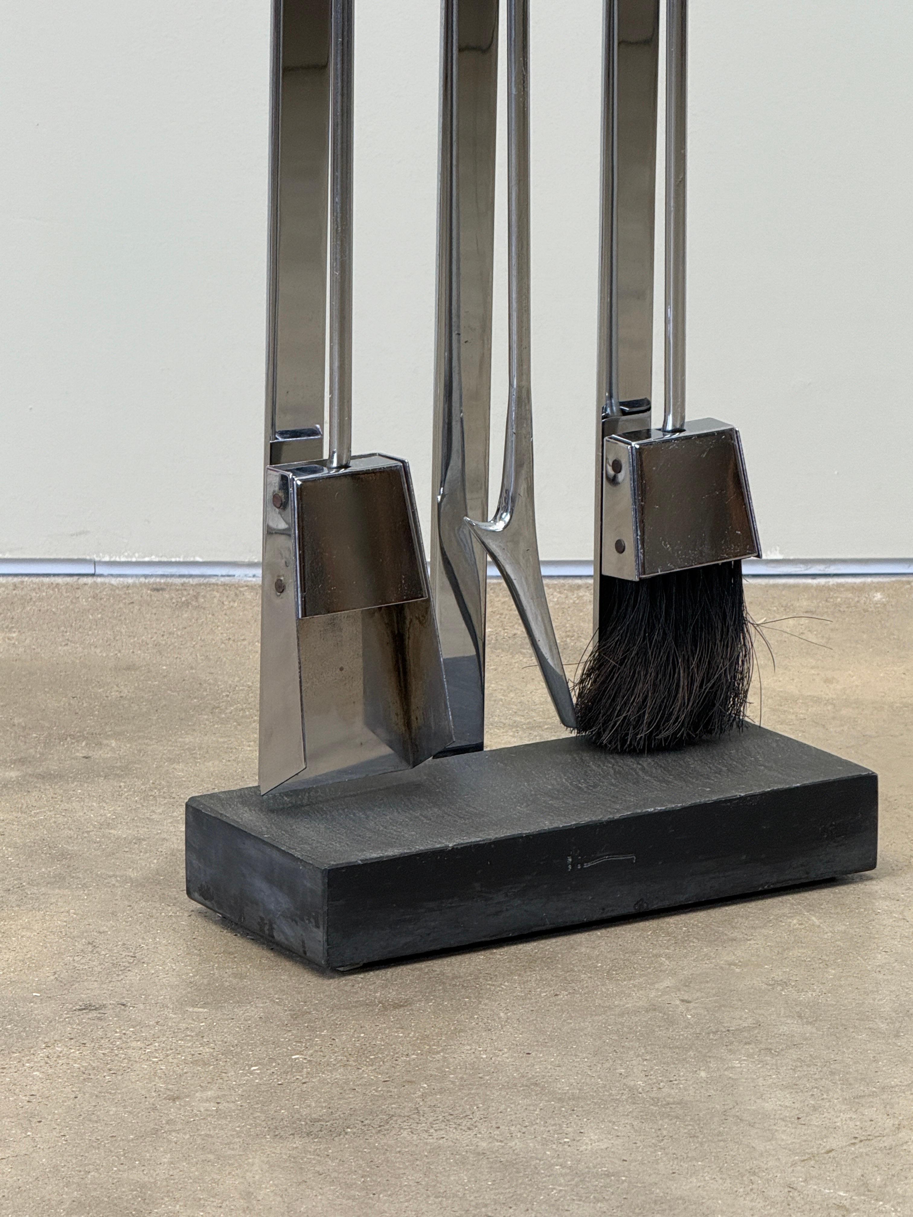 A set of modern fireplace tools on a slate base. Designed by Alessandro Albrizzi. 
