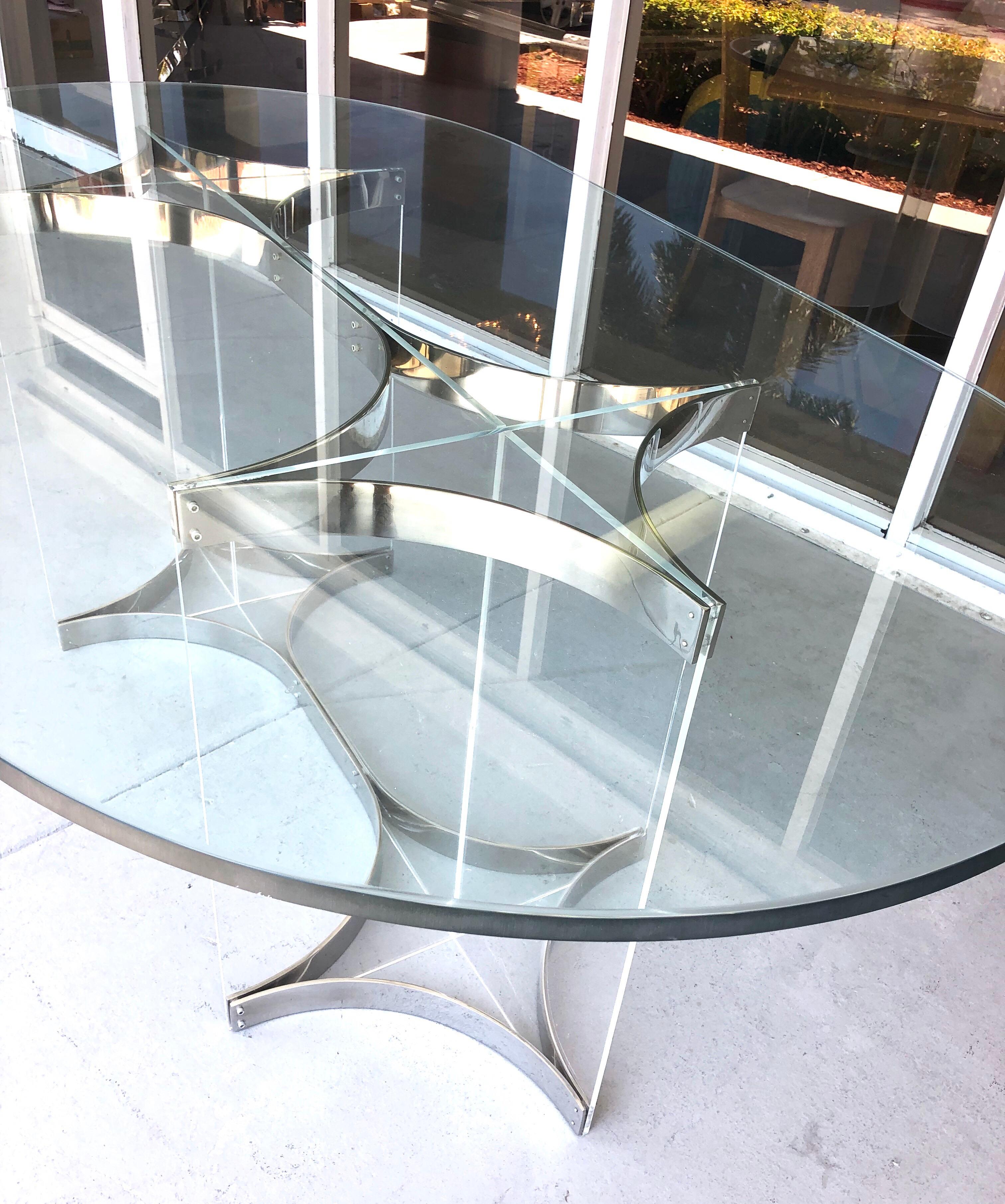 A racetrack dining table by Albrizzi. The base is Lucite with chrome metal. Glass top.
 
