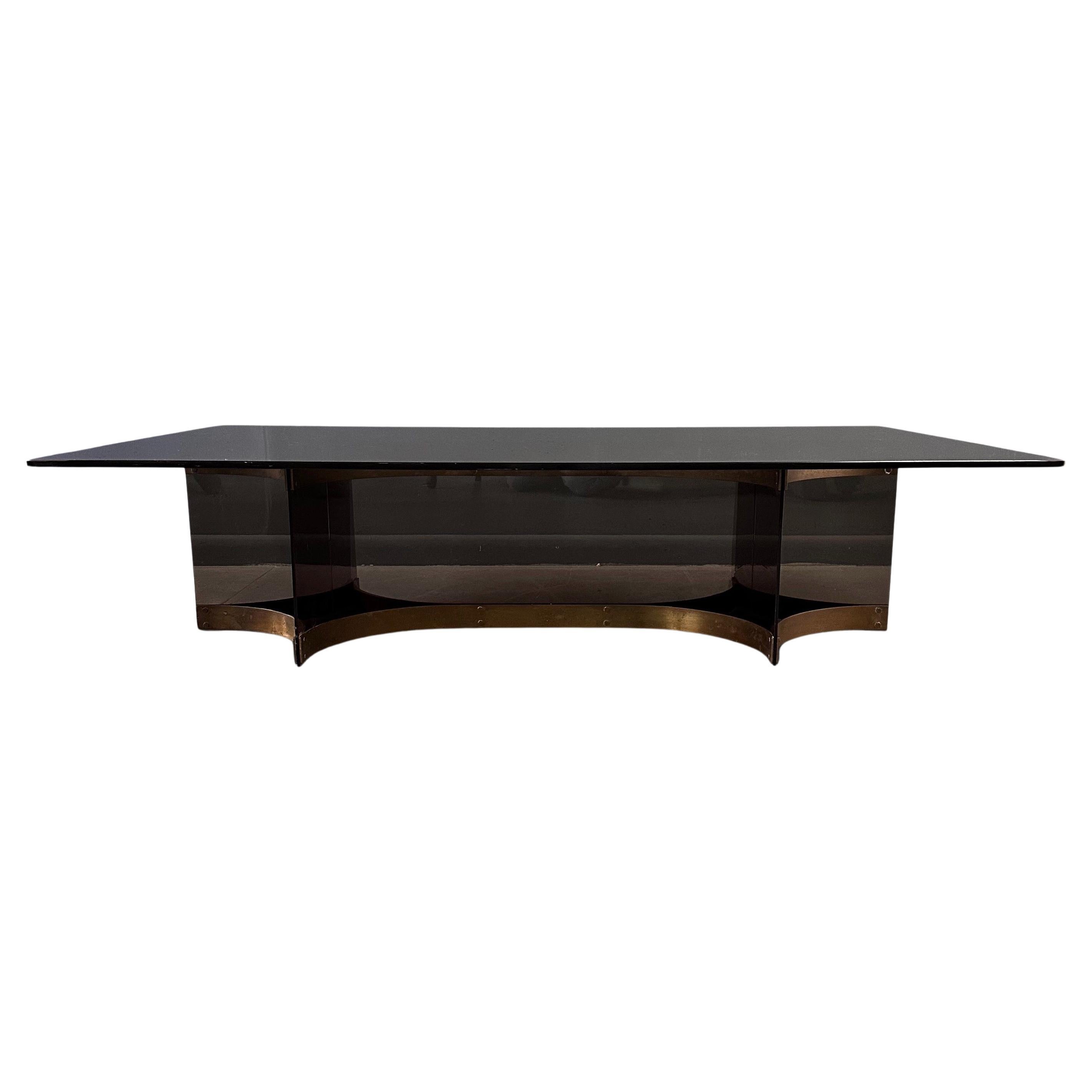 Wonderful graciously proportioned coffee table designed by renown designer Alessandro Albrizzi. This dramatic table with it's smoked glass top and beautifully patinated brass table base will make a dramatic choice for your next project.