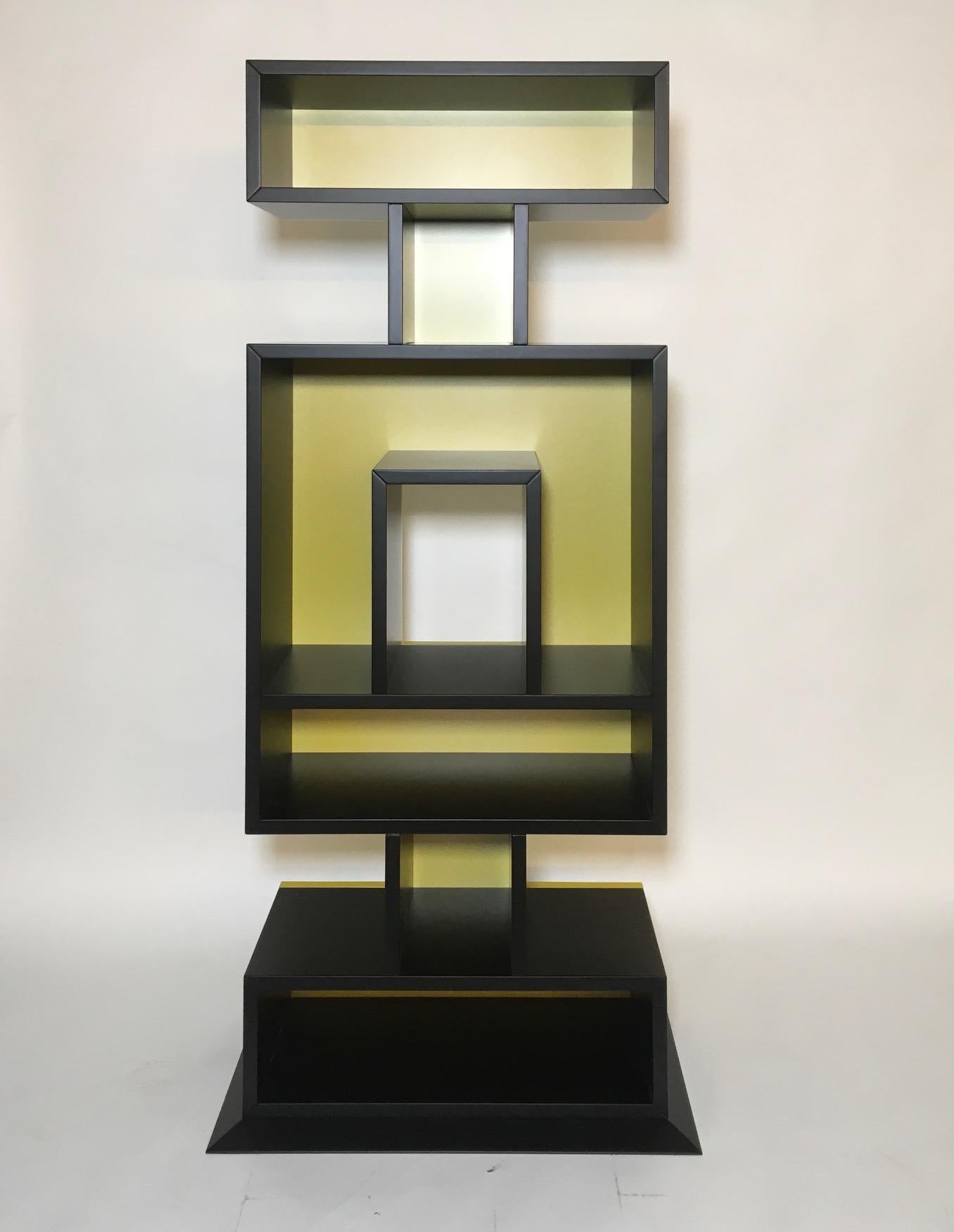 Bookcase Totem Ollo collection, Alchimia, 2019, in lacquered wood black and metallic yellow.

In 1976 Alessandro and Adriana Guerriero established Alchimia, the first example of manufacturing designers in Milan. In 1978 and 1979 they presented the