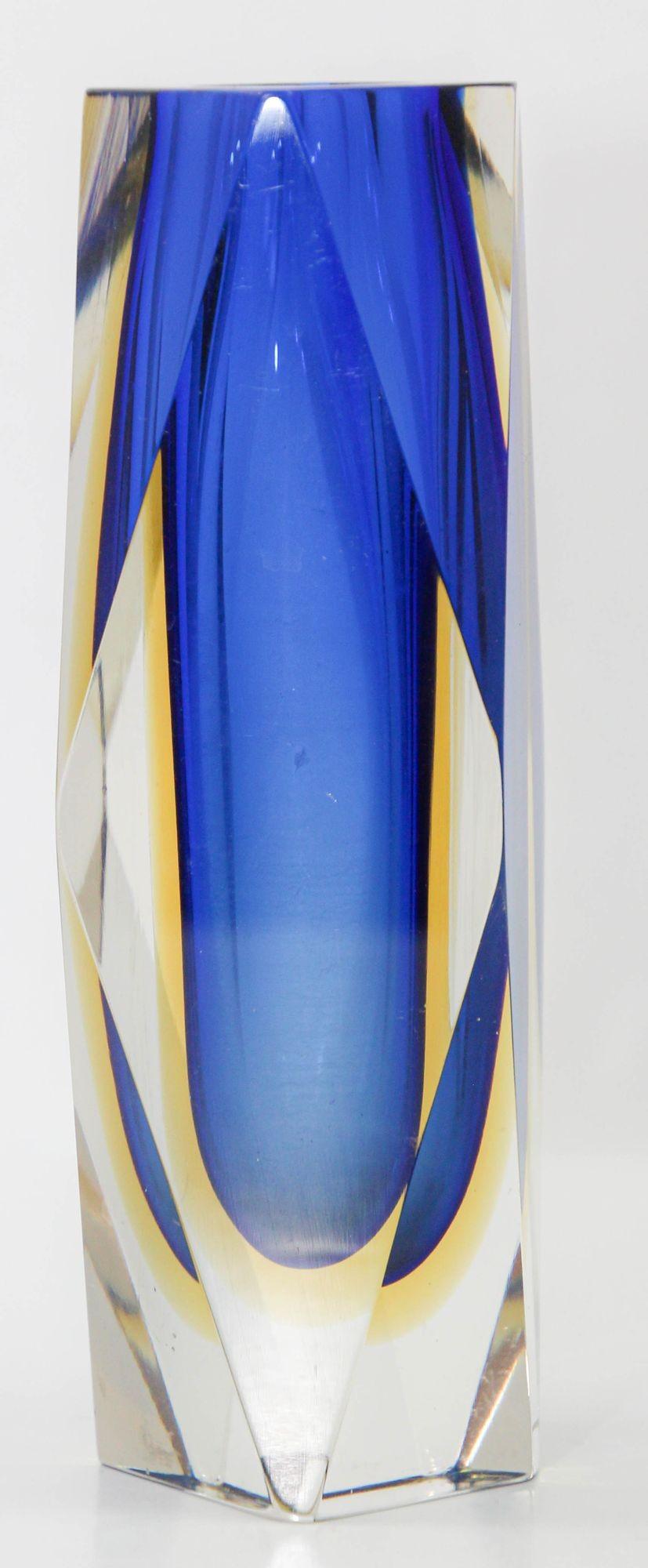A stunning vintage Sommerso Murano glass vase, designed by Flavio Poli and crafted by Alessandro Mandruzzato, showcases a captivating combination of blue, yellow, and clear hues.
This Italian masterpiece from the 1960s features faceted Venetian