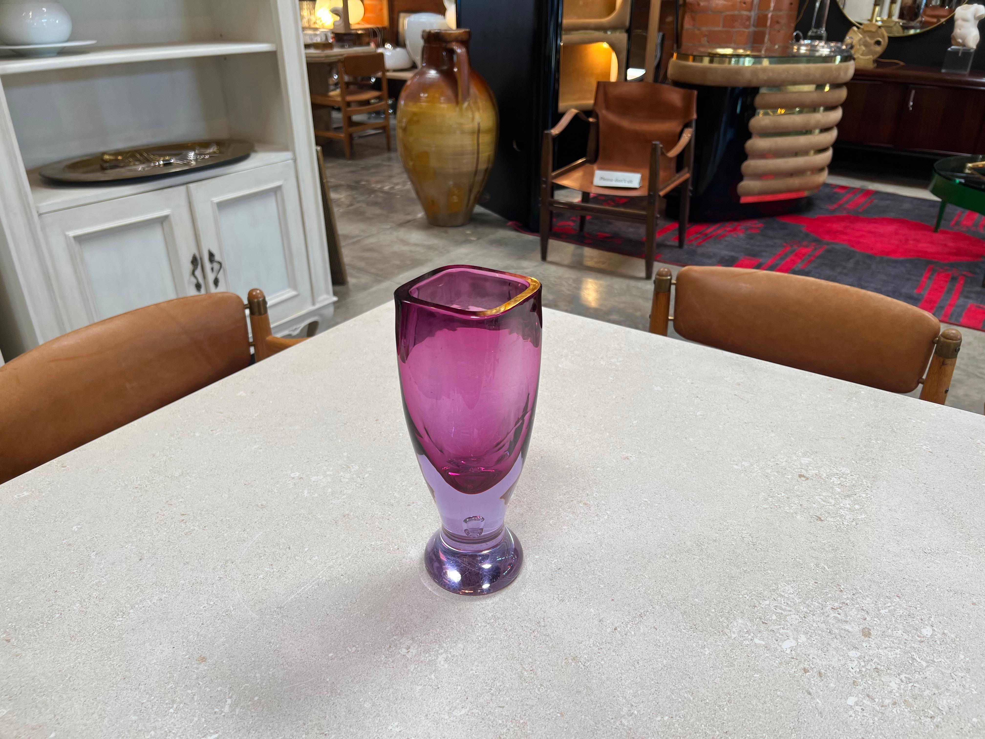 The Alessandro Mandruzzato Vintage Murano Vase from the 1970s is a highly sought-after piece of art glass. Crafted in a stunning shade of purple, this vase is characterized by its exceptional craftsmanship and distinctive design. The rarity of this