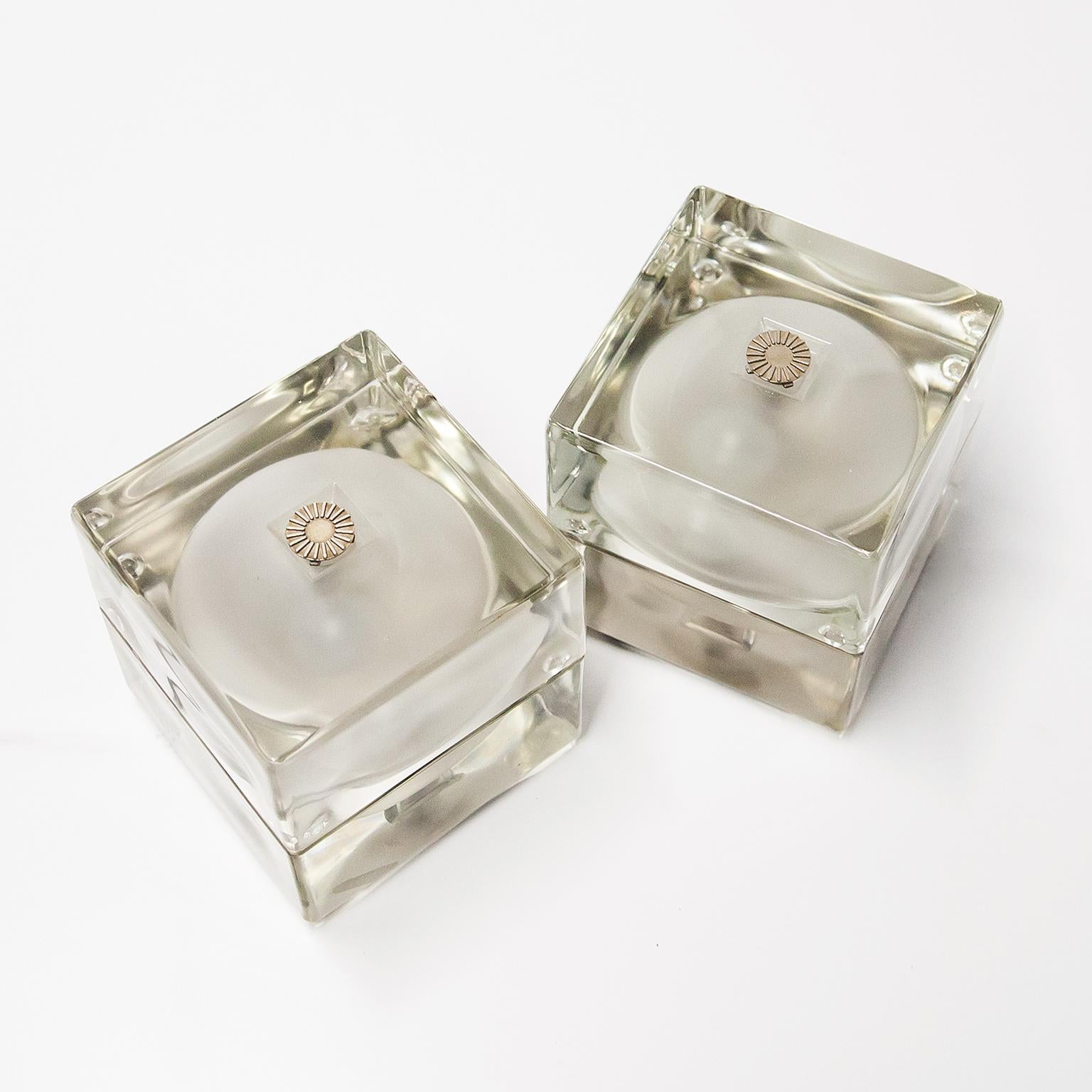 Pair of Cubosfera table lamp designed by Alessandro Mendini for Fidenza Vetraria in Italy 1968. Made of solid transparent glass with metal details. The upper and lower parts together form a cube with a sculpted globe. The lamp is equipped with two