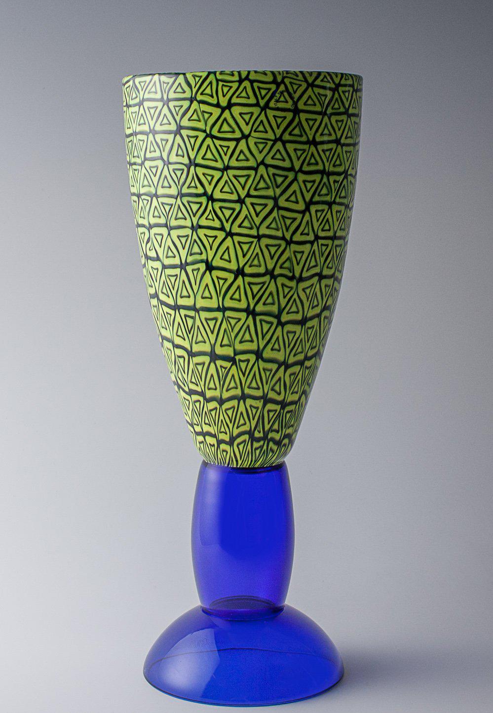 Alessandro Mendini. 'Grande Brindisi' vase, designed in 2000. H. 40.1 cm. Made by Venini & C., Murano.
Blue glass, coupe inside and out with fused murrhine in yellow and deep purple. Marked: Venini Millennium III 45/ 99 A. Mendini (engraved);