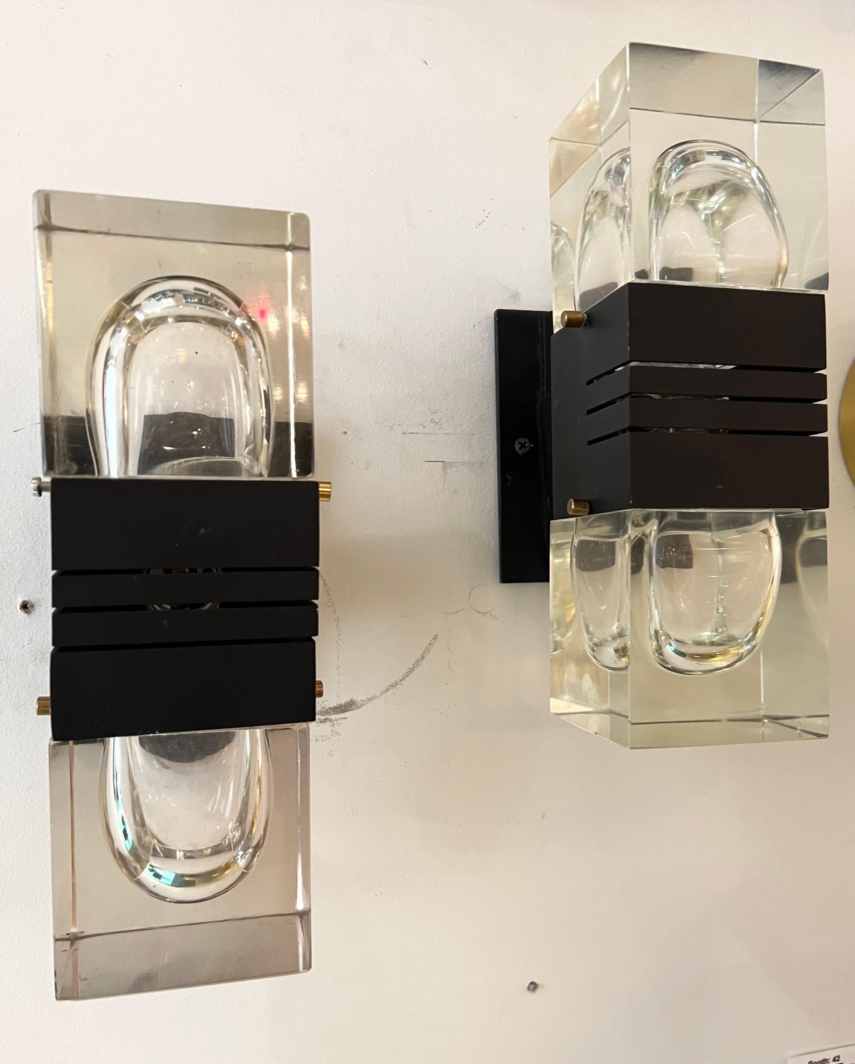 A masculine pair of heavy matte black steel framed wall lights with thick cubes crystal shades . The upper crystal is clear and the bottom has a very slight darker tint. Light emits thought the frame as well as the cubes . Very rare designed by