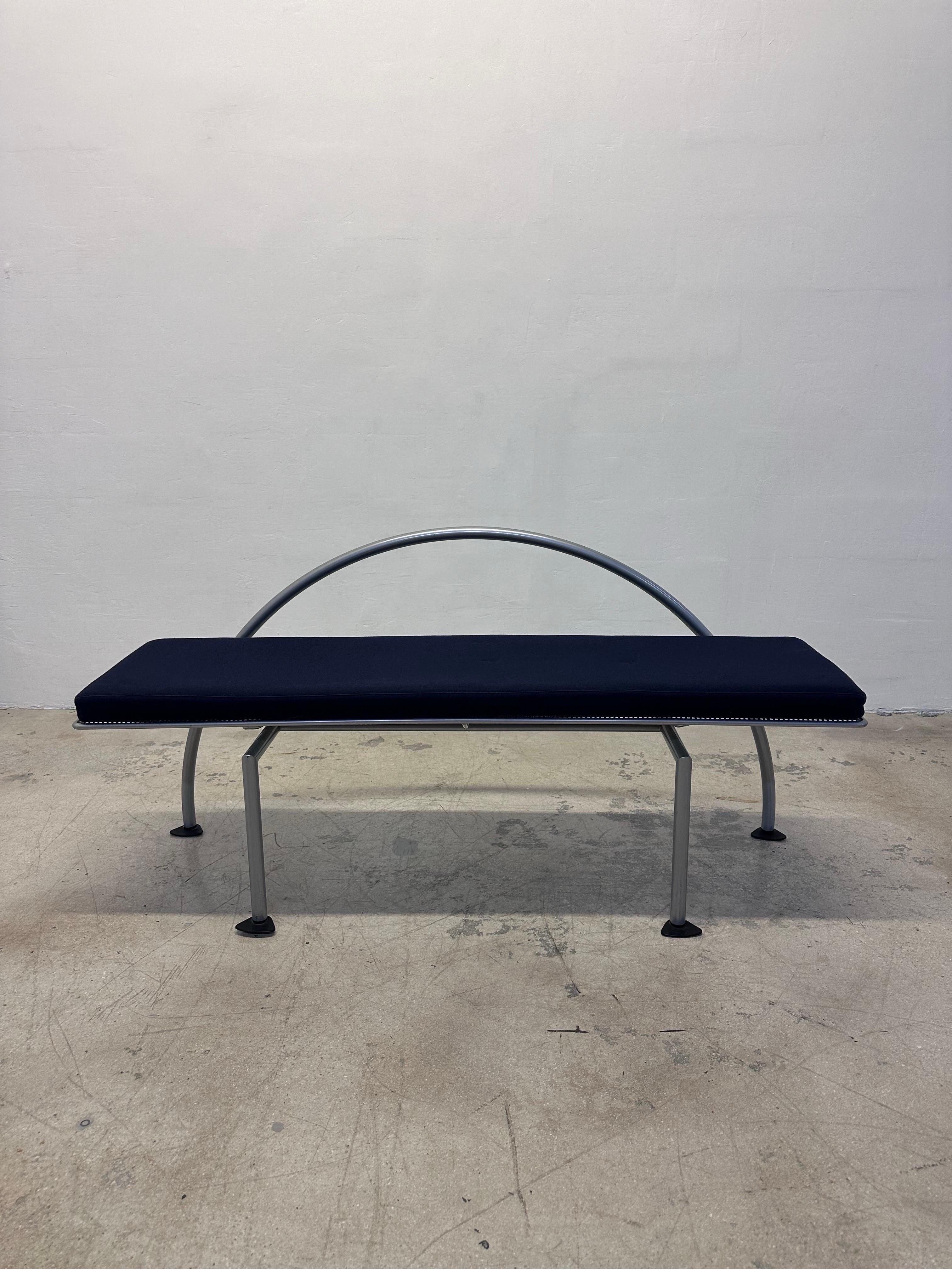 Rare Memphis era Karina bench by Alessandro Mendnini and part of the series Poesie d’Anticamera. Grey epoxy steel tube, perforated steel seat with blue felt cushion. Italy 1980s.
