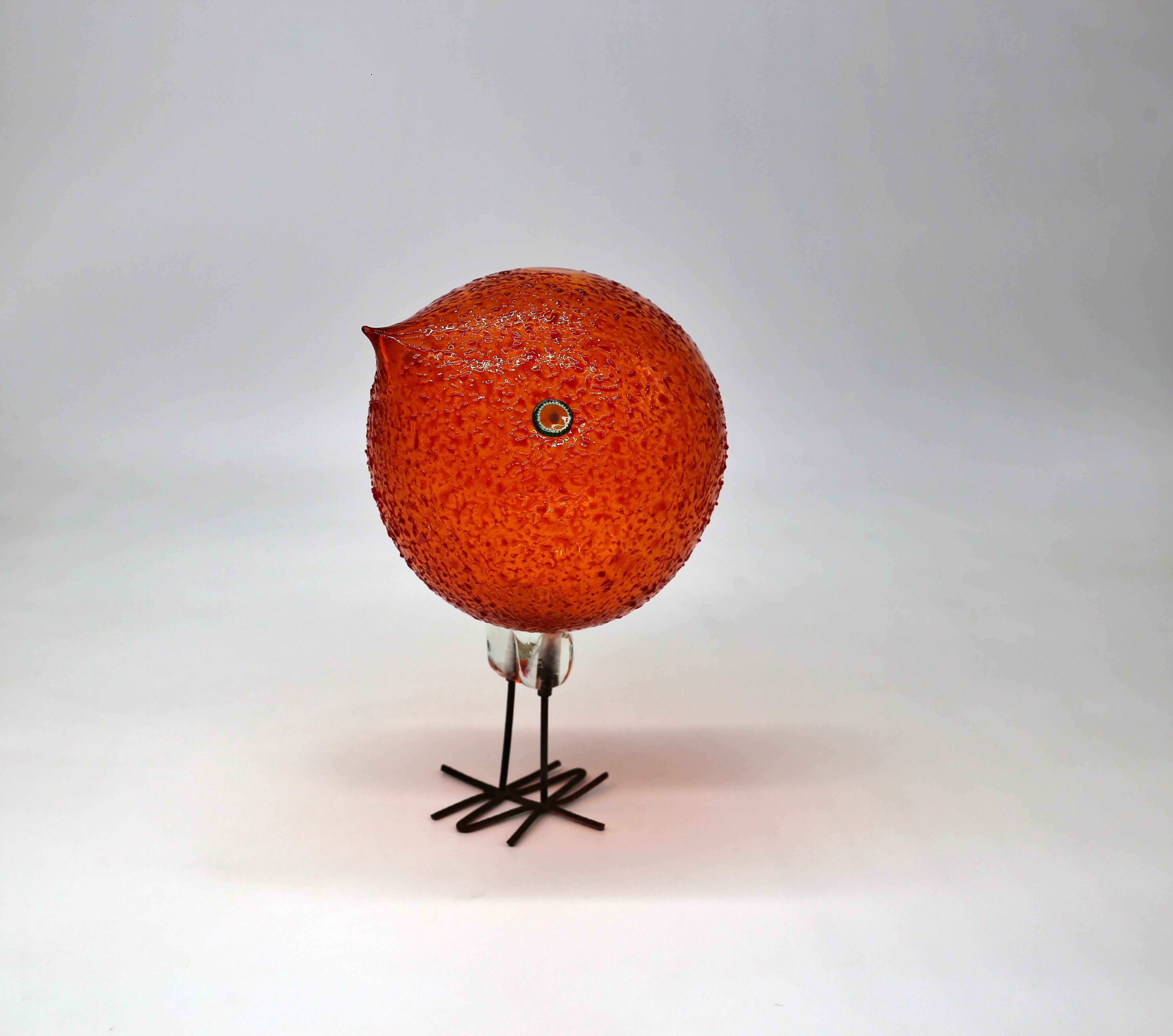 Spherical shape. H. 23 cm. Execution: Vetreria Vistosi. Glass, colorless and orange with fused crushed glass, applied murrine as eyes; feet made of bent copper wire.
Literature: Cf. Marc Heiremans, Murano Glass, Stuttgart 1996, p. 163.