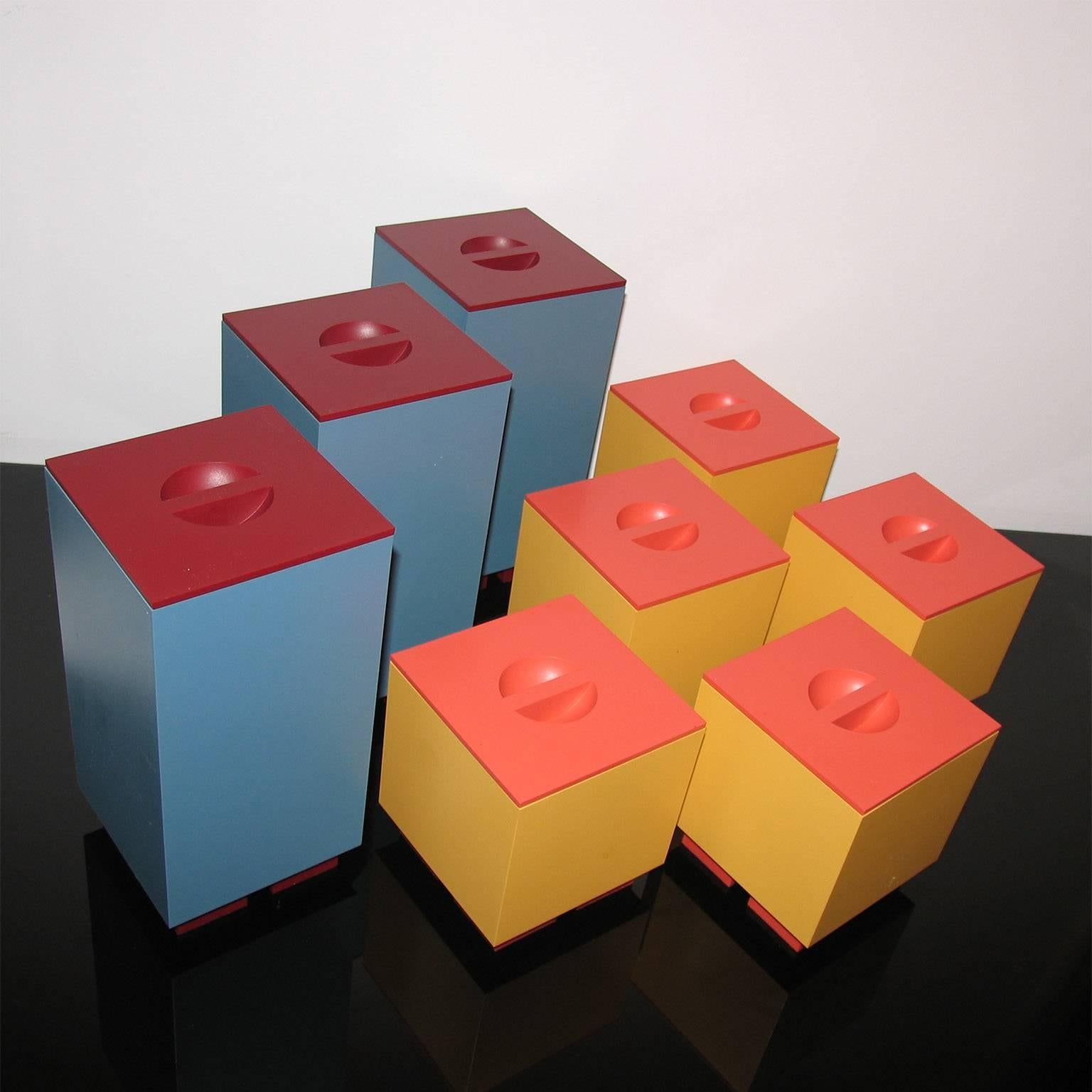 Alessi Euclid, Memphis series, Design Michael Graves, Italy, 1980s.
Boxes with covers, designed by Michael Graves for Alessi.
Three tall boxes in blue with dark red covers and feet.
Five shorter boxes in yellow with orange covers and feet.
Each