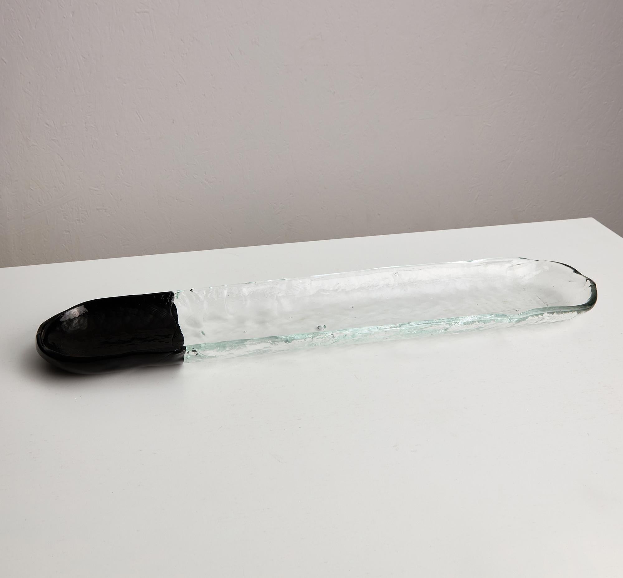 Descubre la Bandeja de cristal para servir Alessi: una hermosa fusión de elegancia y practicidad. Esta bandeja transparente luce un elegante borde negro, que infunde una moderna sofisticación a cualquier ambiente. Tanto si la utilizas como centro de