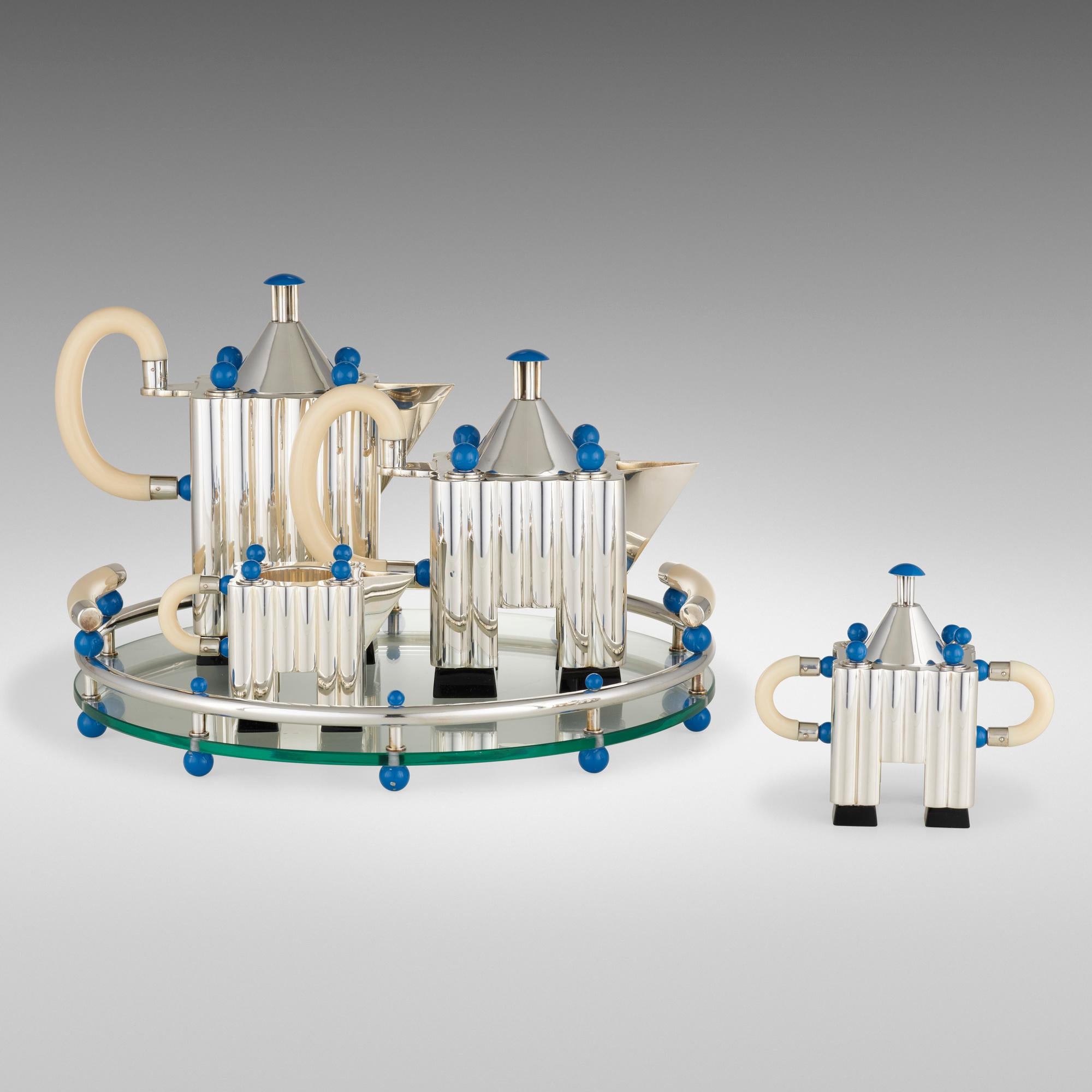 Michael Graves (USA)
ALESSI SpA (Crusinallo, Omega, Italien)
Italienisch 925 Reines Silber
Limitierte Auflage Kaffee & Tee Piazza mit Tablett
Ausgabe # 64 / 99
(Design: 1984 / Produktion: 2003)

Beschreibung:   Das Set besteht aus einer silbernen