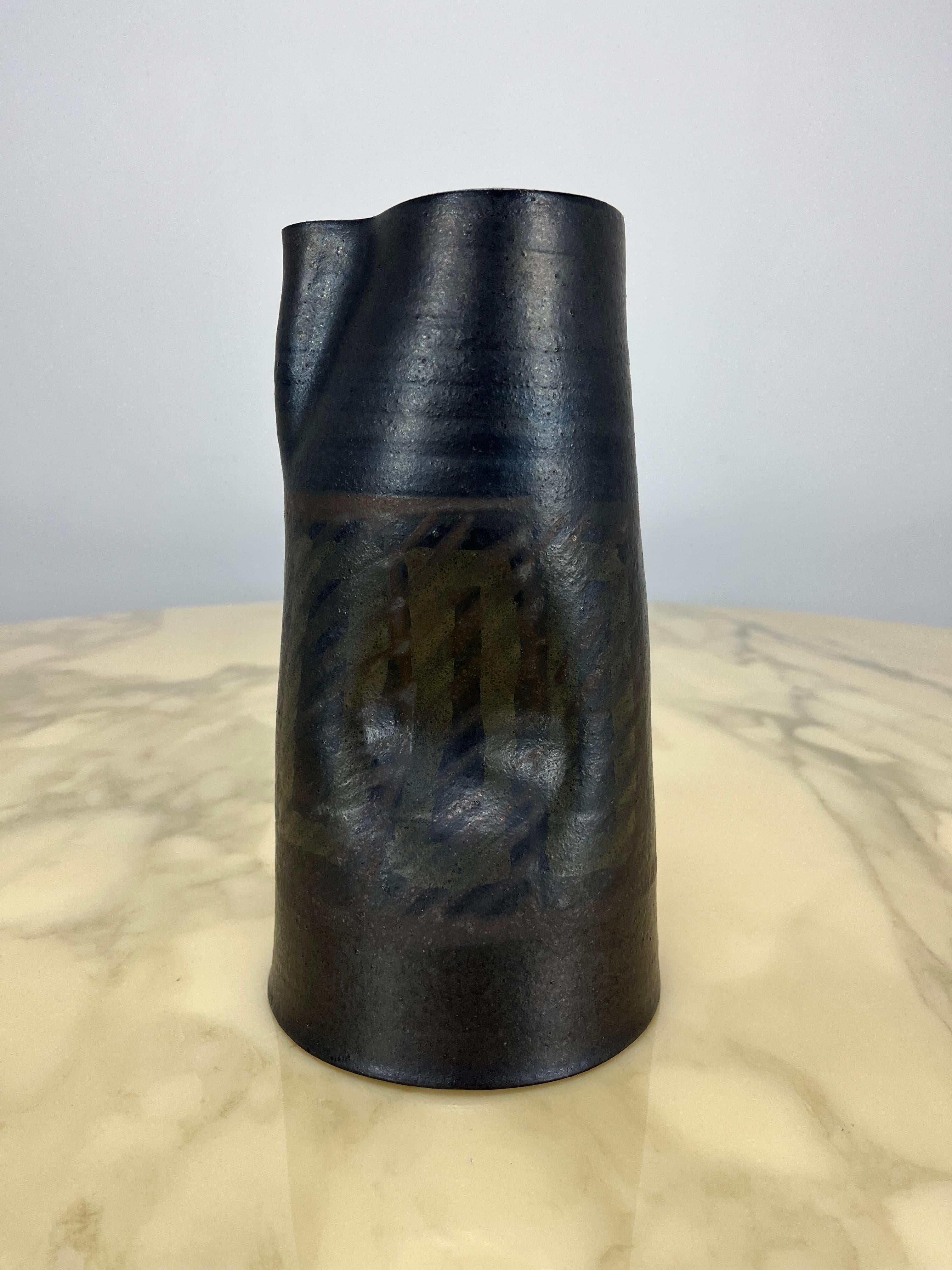 Rara jarra de cerámica esmaltada negra de Alessio Tasca. Bonito esmalte azul claro en el interior. Diseño ergonómico con dos concavidades en los laterales que sirven de asa. 