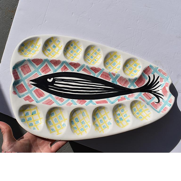 Fantastic abstract platter hand painted and decorated with a fish to the center (possibly of a Salmon?) and 12 divots for placement of oysters or eggs. A wonderful find, and a spectacular way to add fun and whimsy to a supper