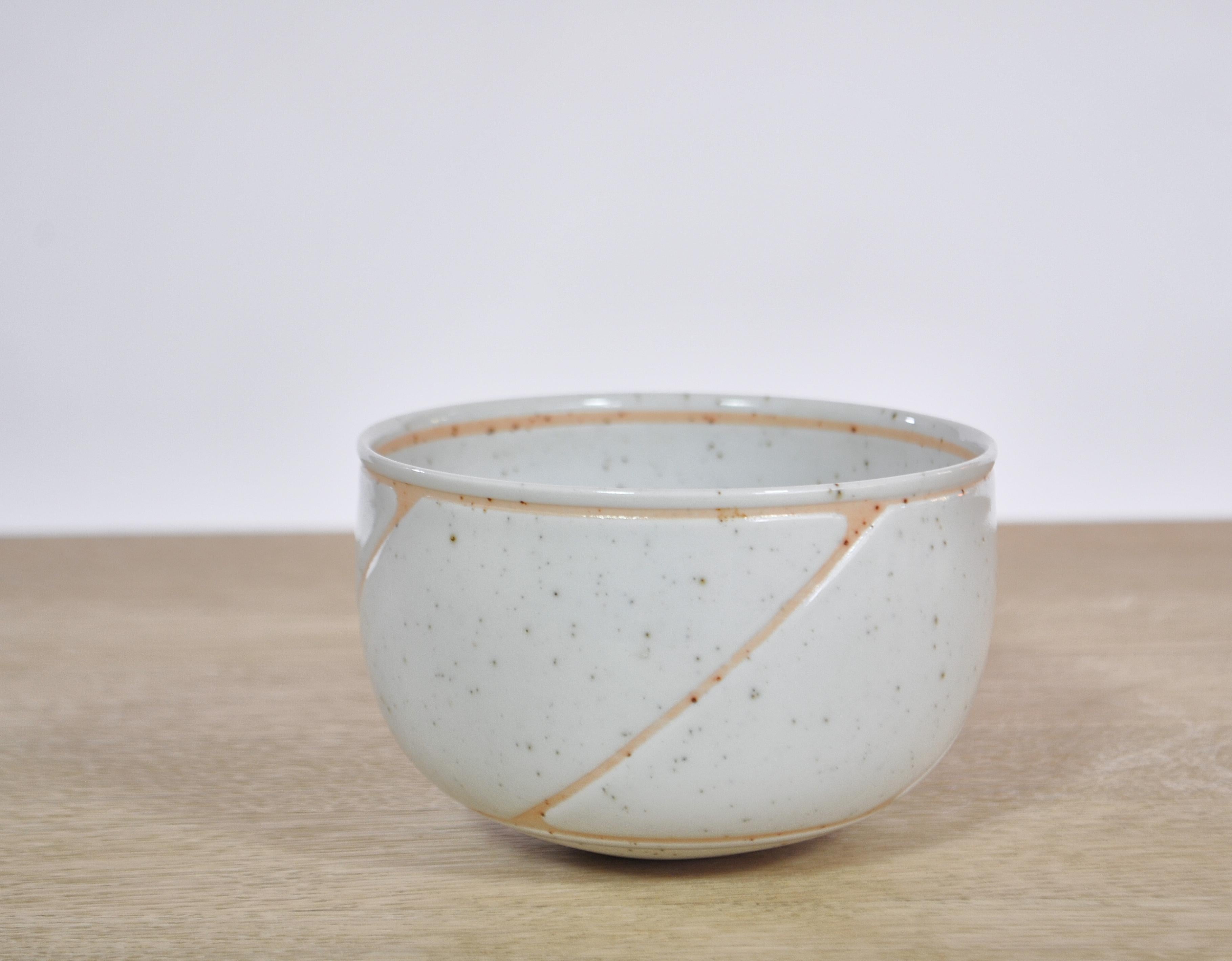 Beautiful stoneware bowl with rounded sides and straight rim and with resist decoration and speckled grey glaze by Danish/Turkish ceramist Alev Siesbye. This design is from 1977 and features her trademark shape and decoration. Signed and marked.