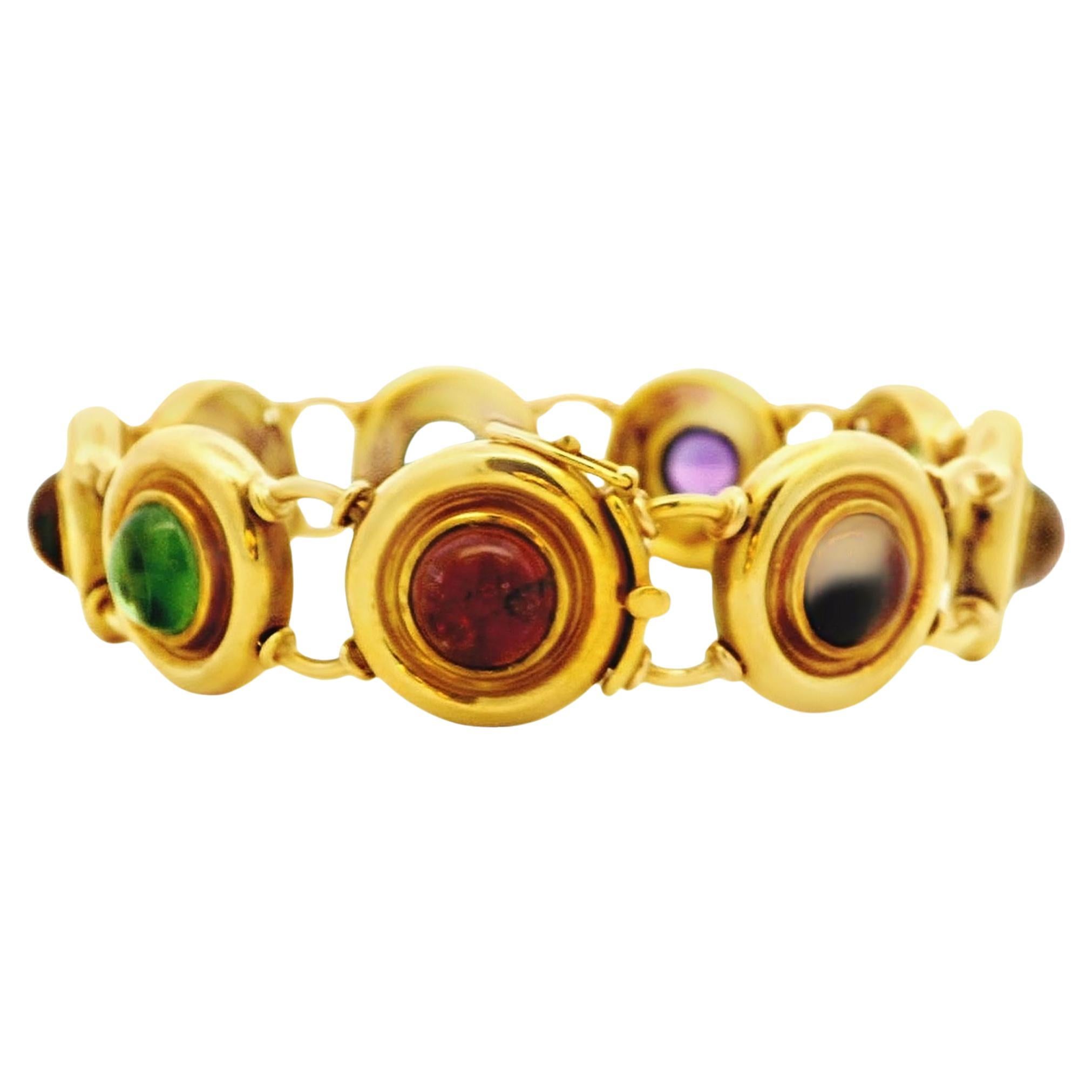 Classically designed and offered by Alex & Co. This wonderful handcrafted 18 Karat yellow gold bracelet is composed of multi color bezel set round cabochons. There are 9 stones in total, collectively weighing 20.88ctw. Each stone is set in a large