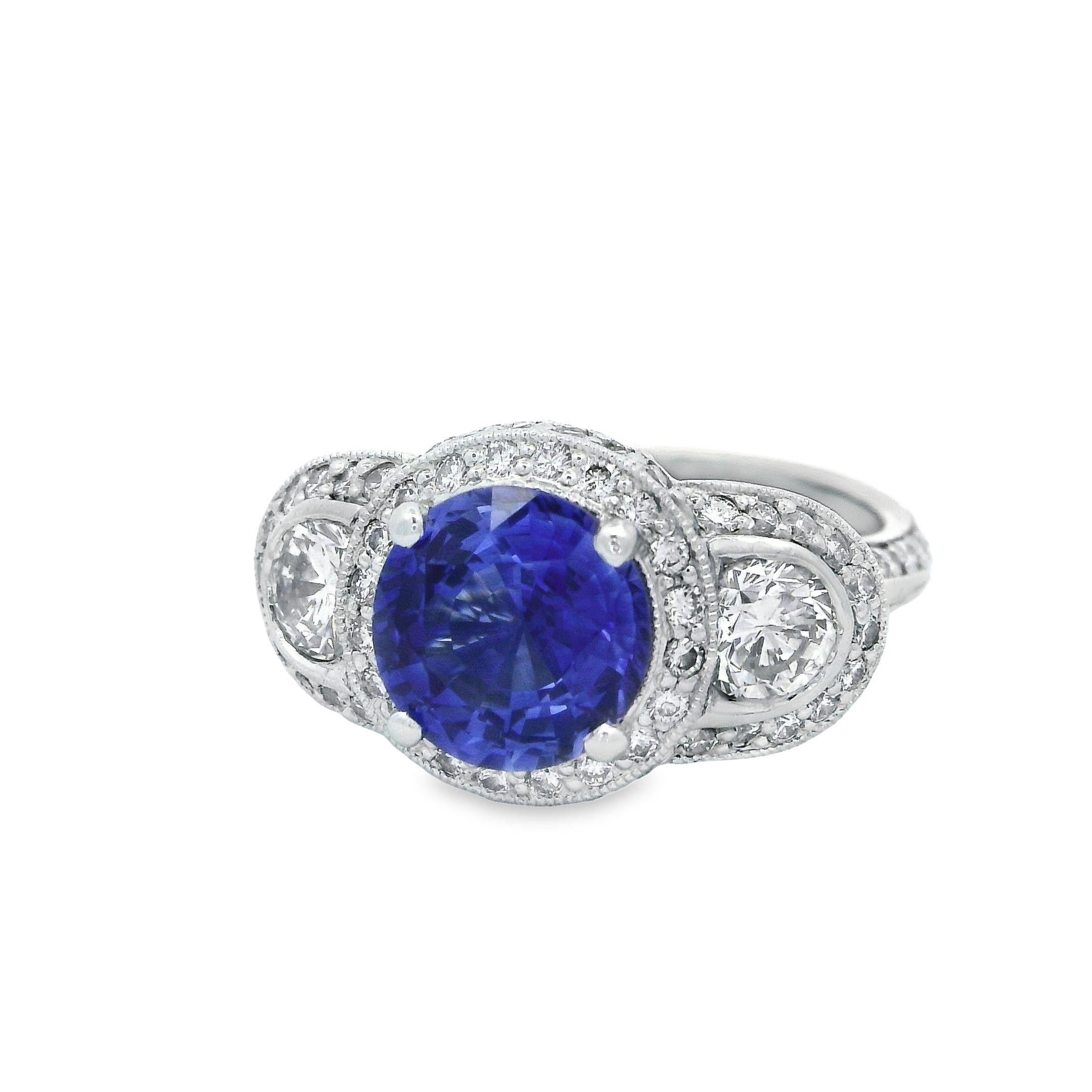 Alex & Co signature AGTA certified stunning 2.72ct round blue sapphire has no indications of heat treatment.  This exquisite ring features 2 round brilliant cut diamond weighing a total weight 0.74ct on the sides bezel set. The 3 stones are